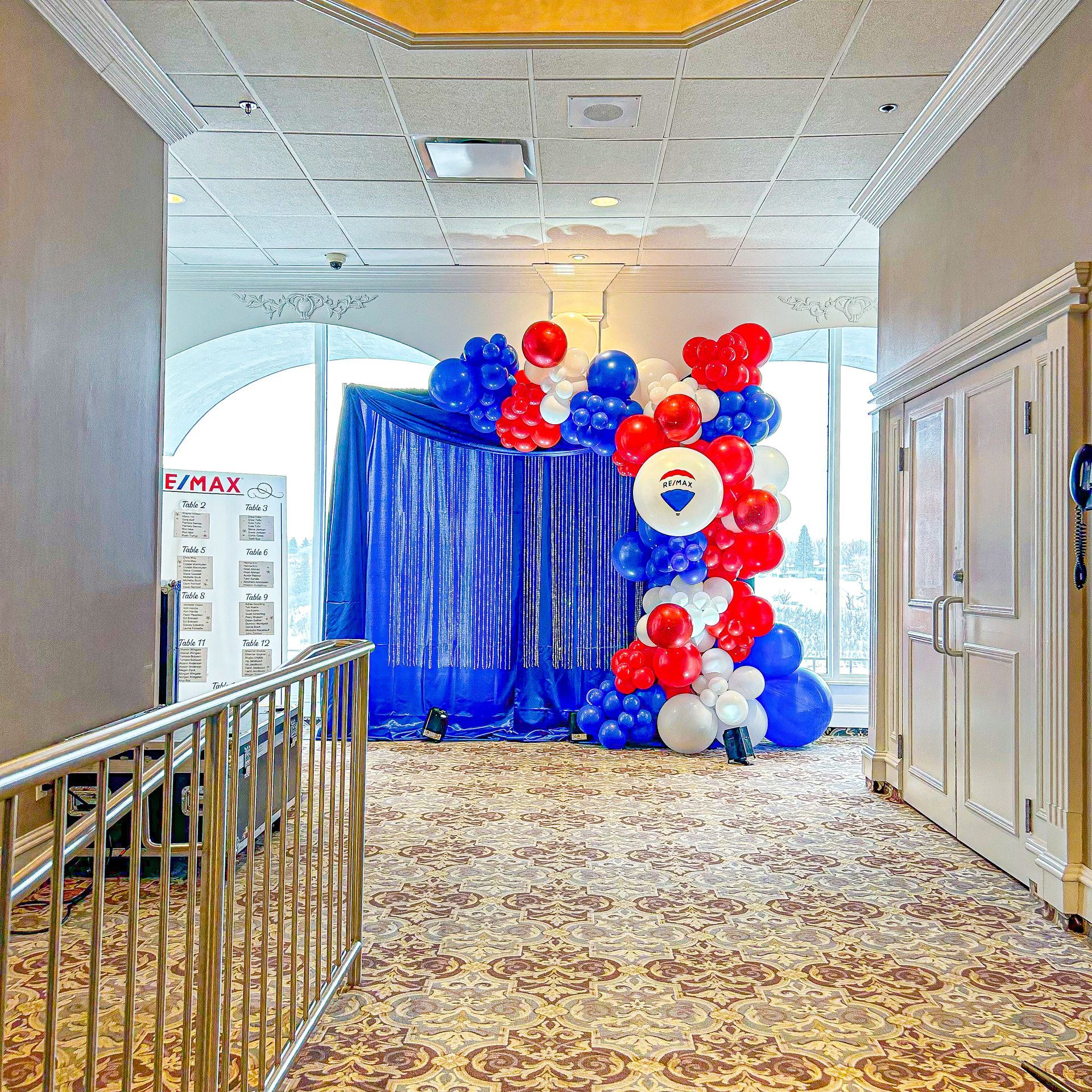 A hallway filled with red white and blue balloons