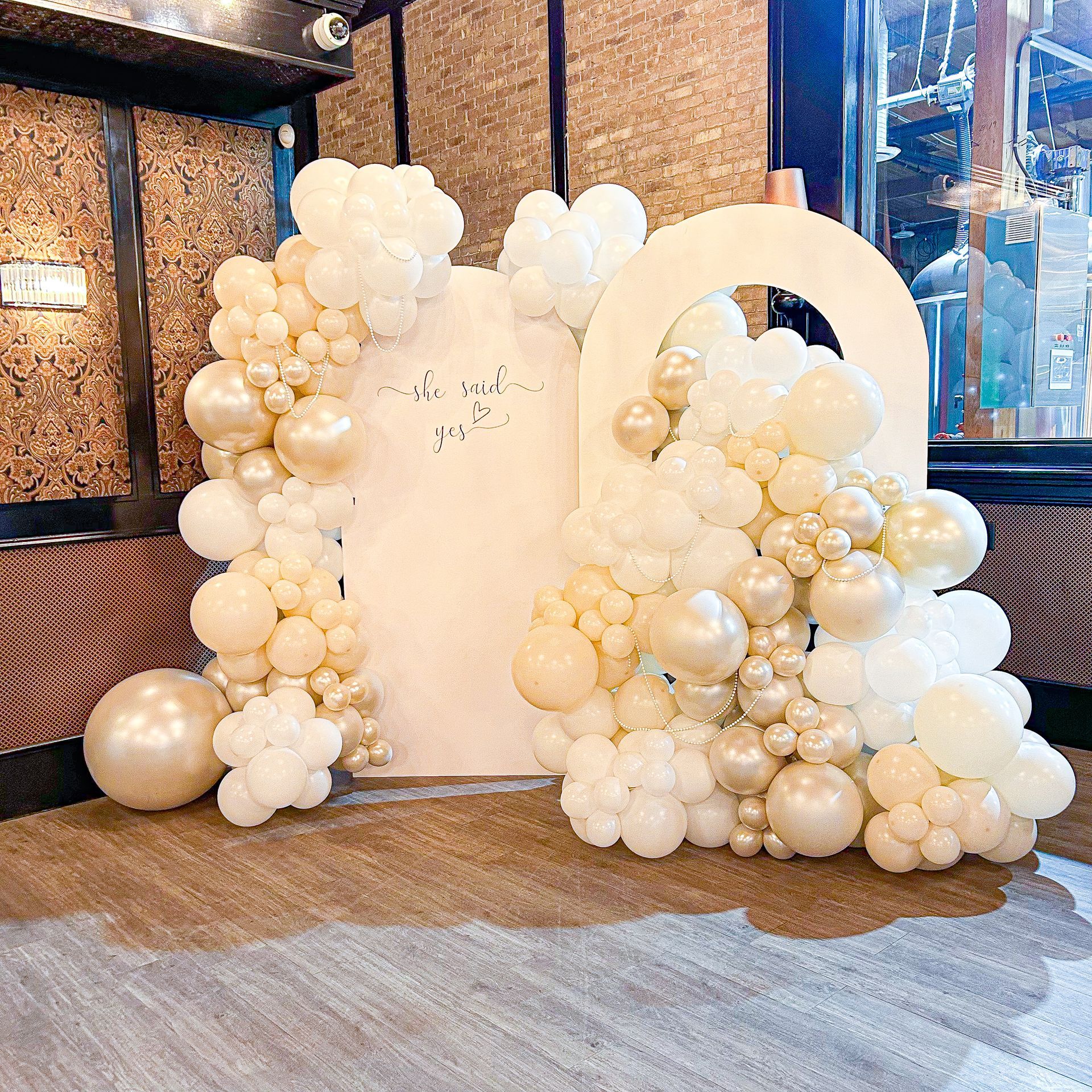 A room filled with lots of white and gold balloons.