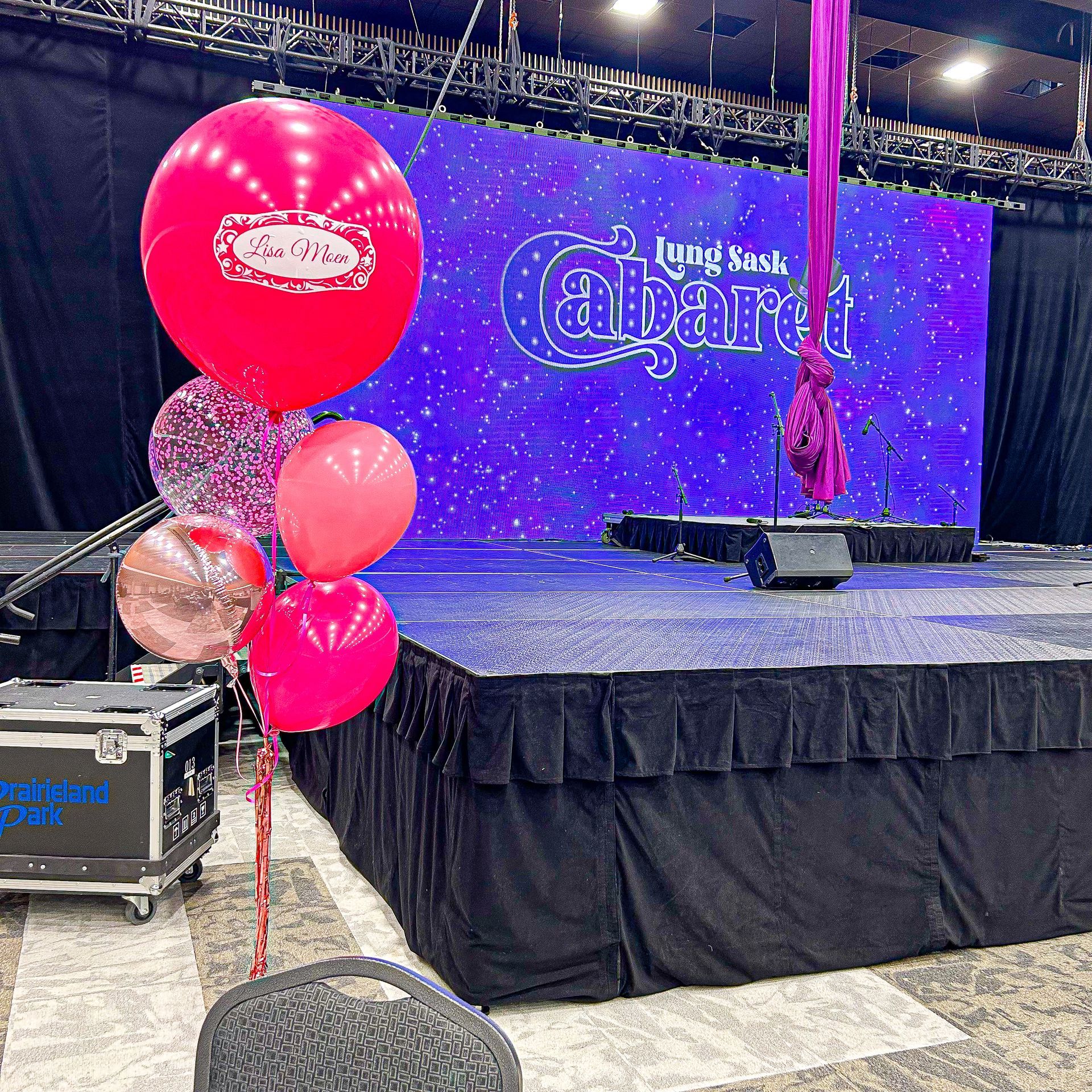 A stage with balloons in front of a screen that says cabaret