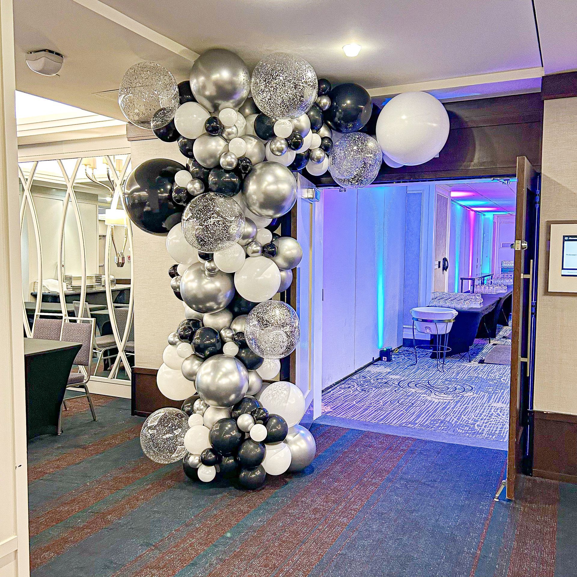 A bunch of balloons are hanging from the ceiling in a room.