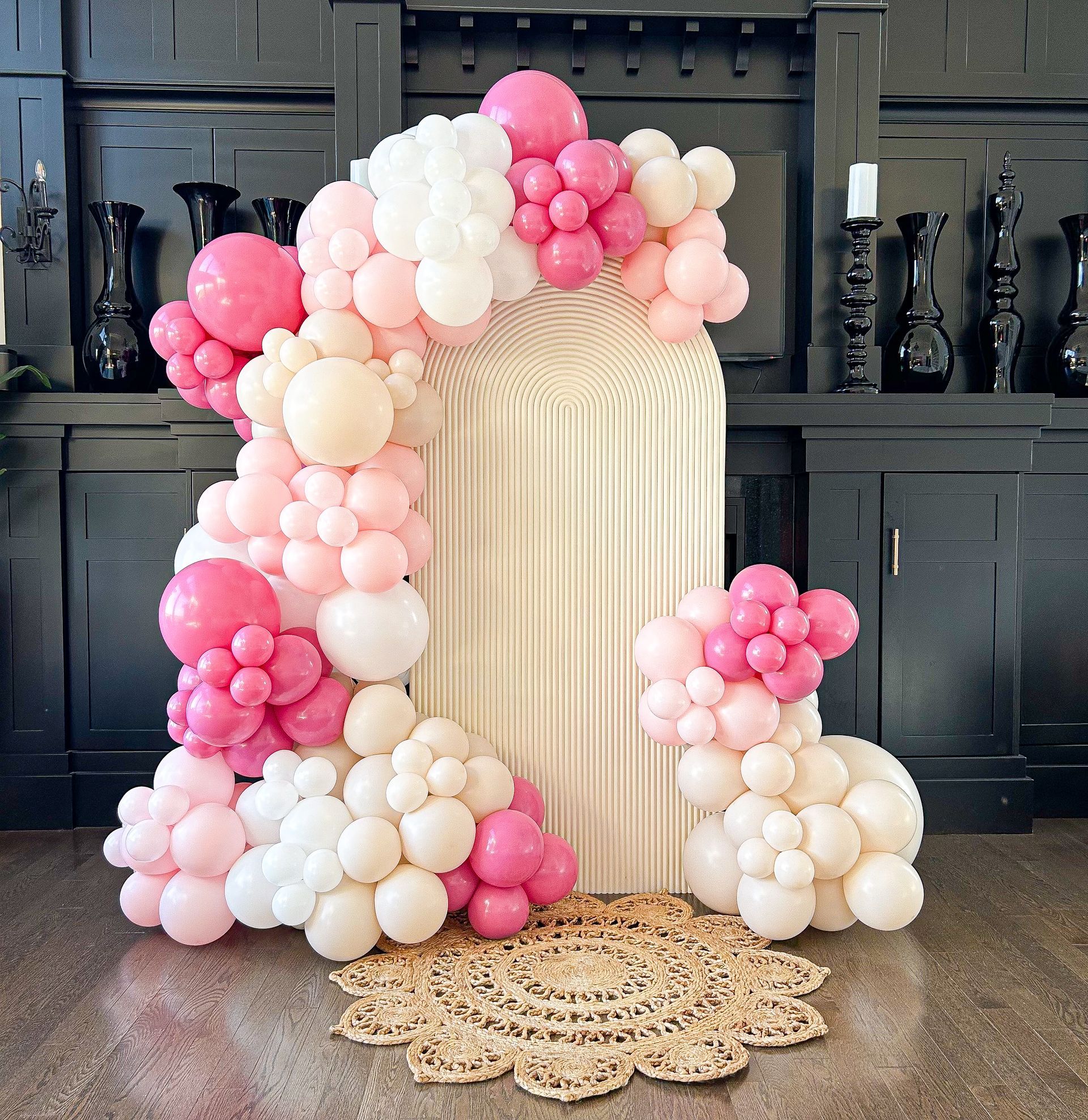 A room decorated with pink and white balloons and a rug