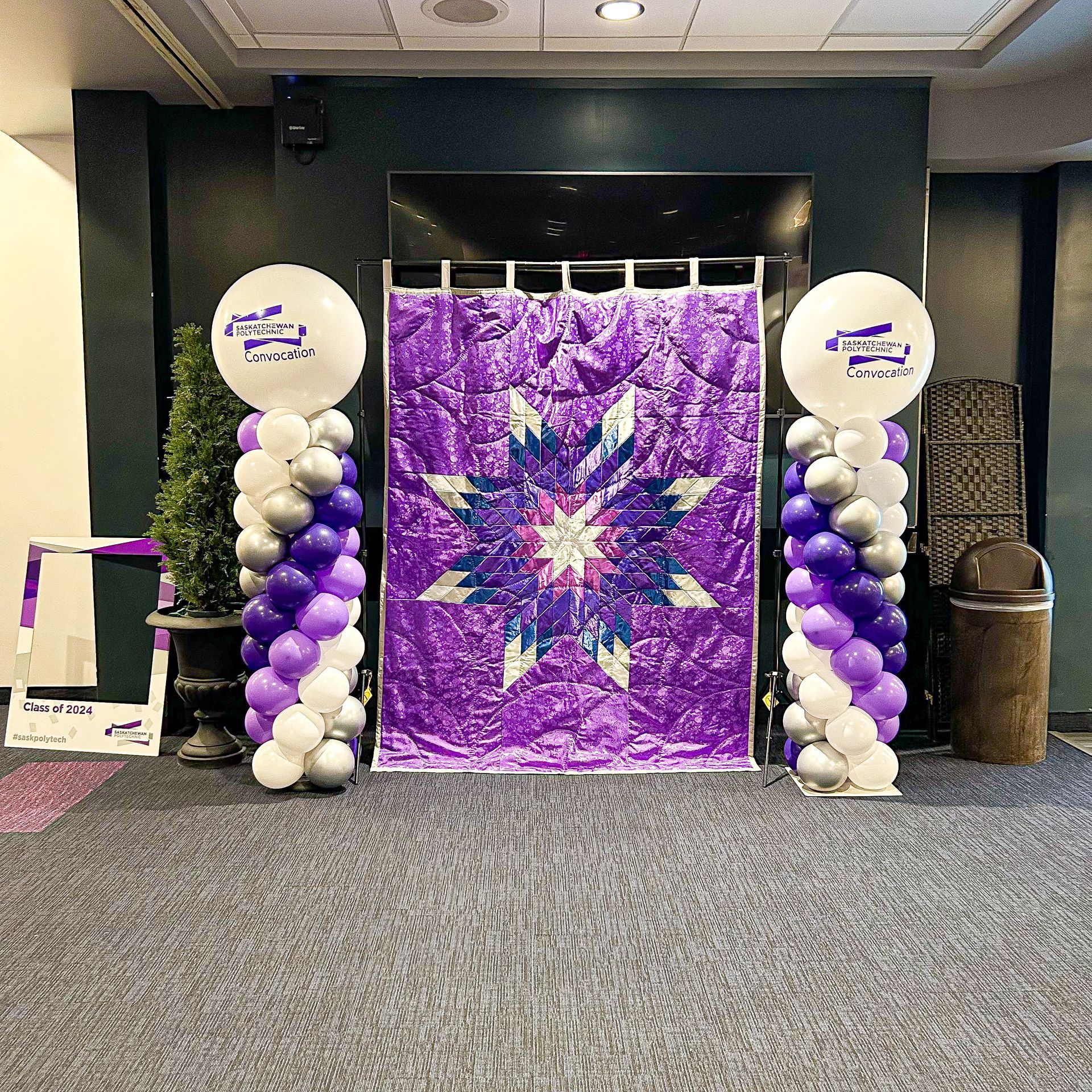 A room with purple and white balloons and a purple quilt