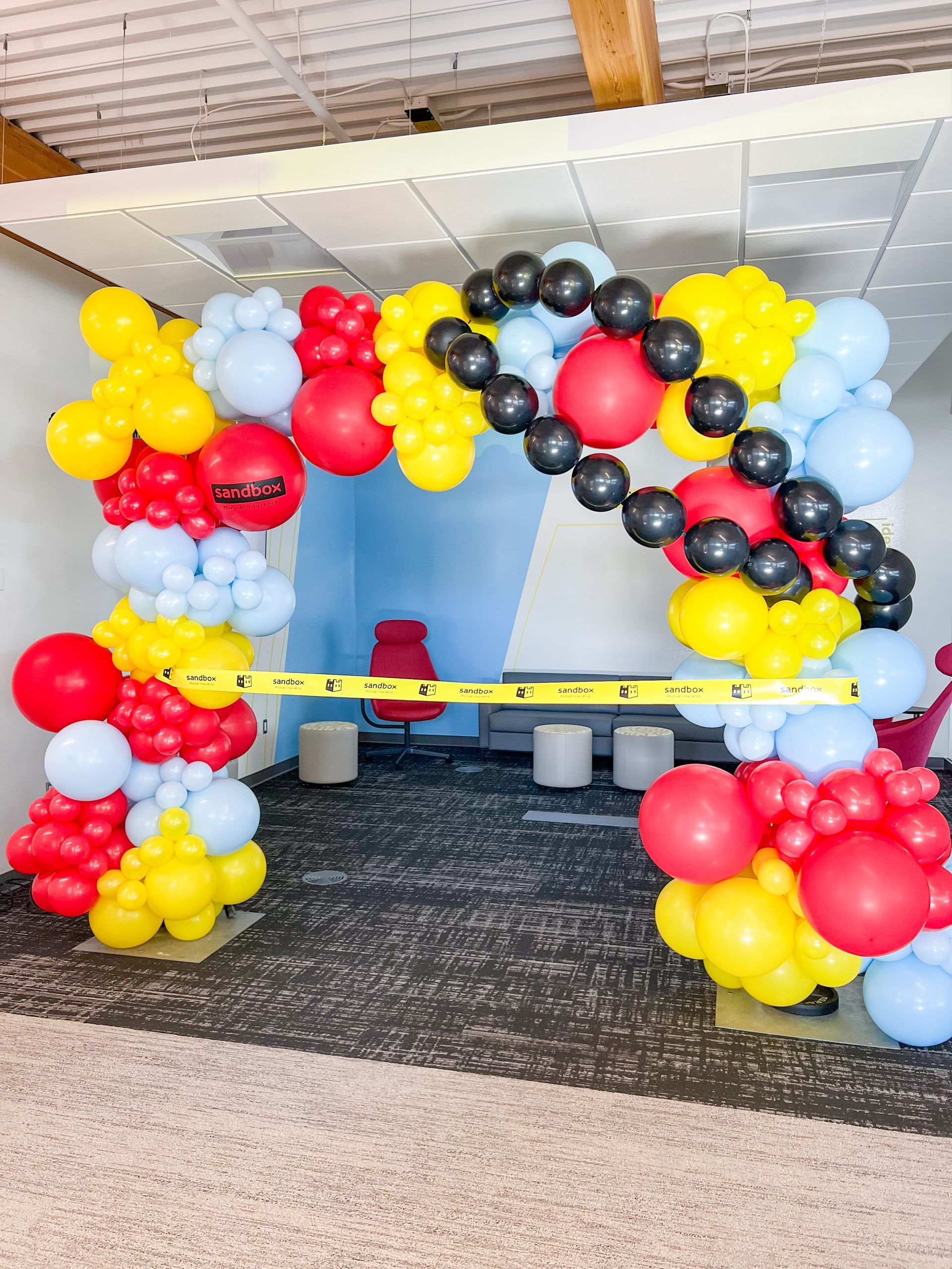 A room filled with balloons and a yellow tape measure.
