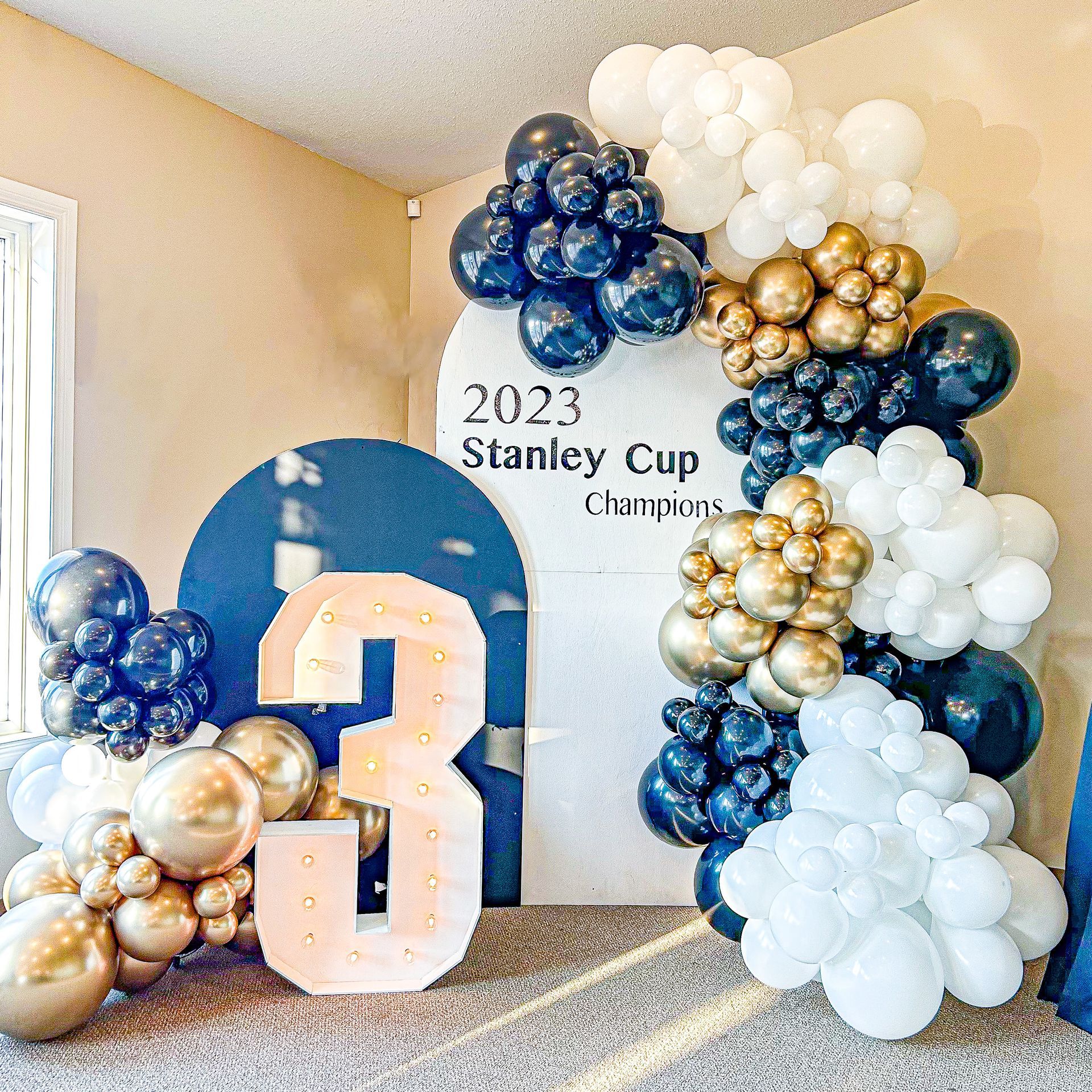 A room filled with balloons and a sign that says `` stanley cup champions ''.