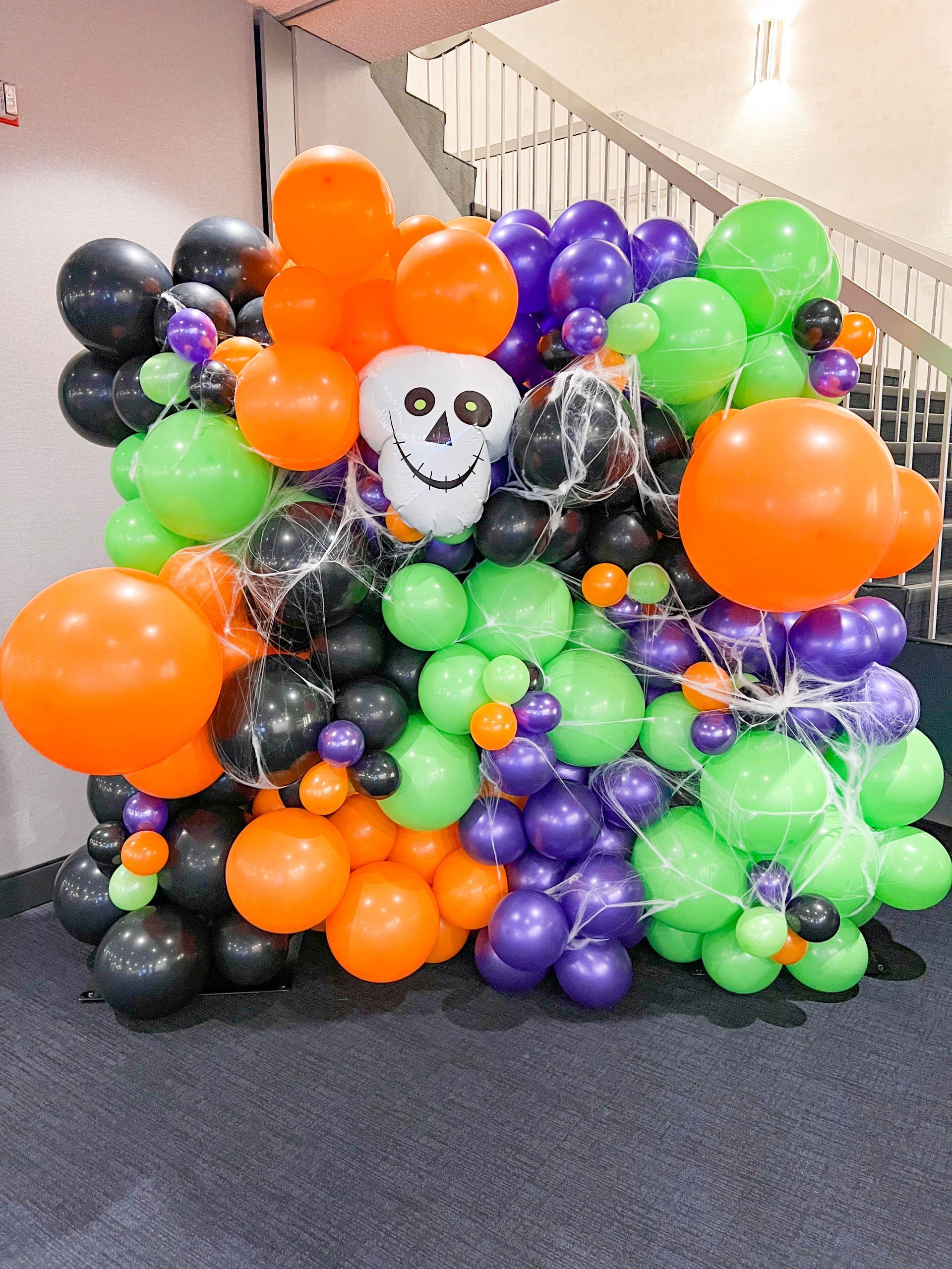 A bunch of halloween balloons are sitting on the floor.