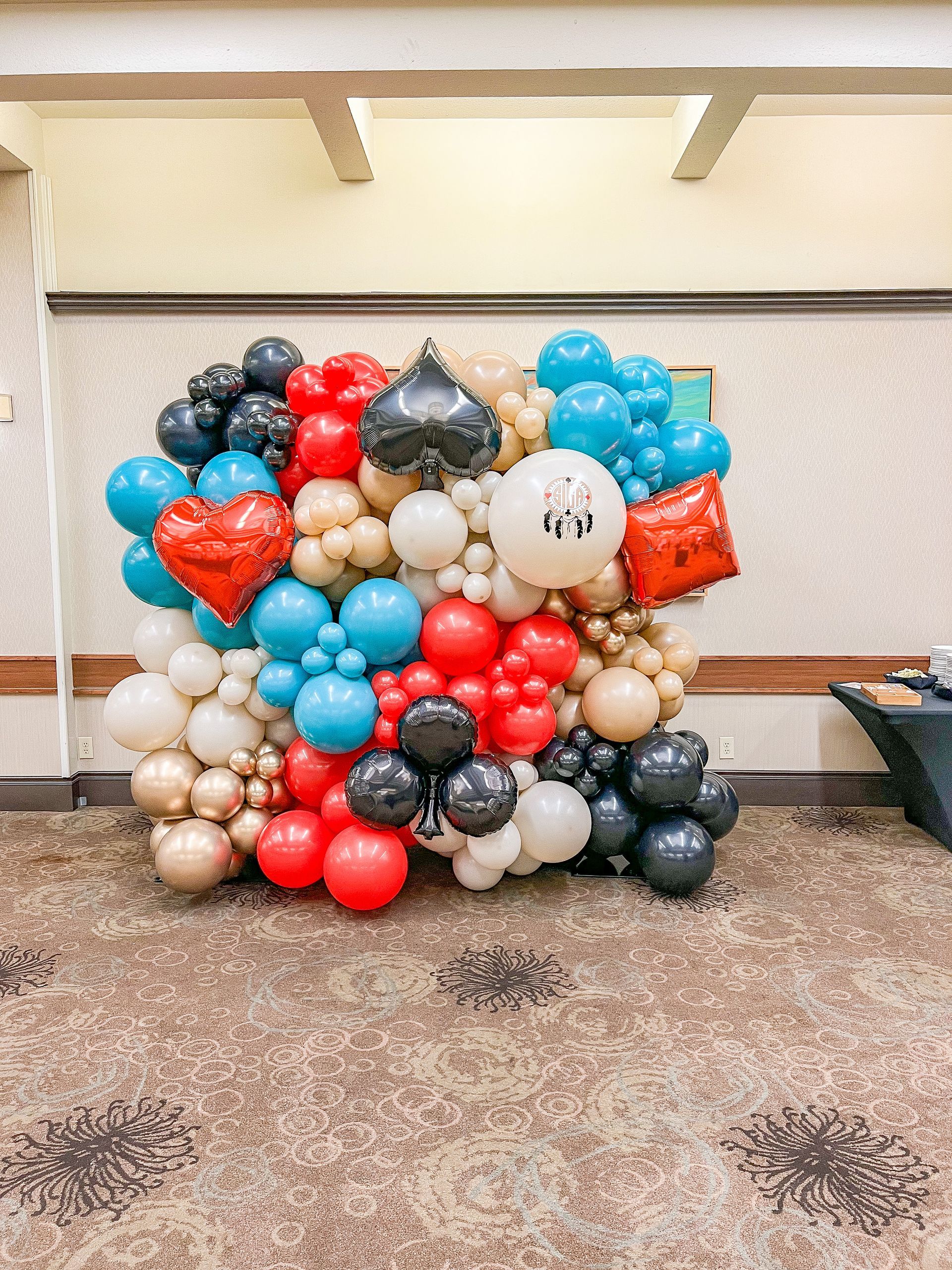 A wall of balloons is sitting on the floor in a room.