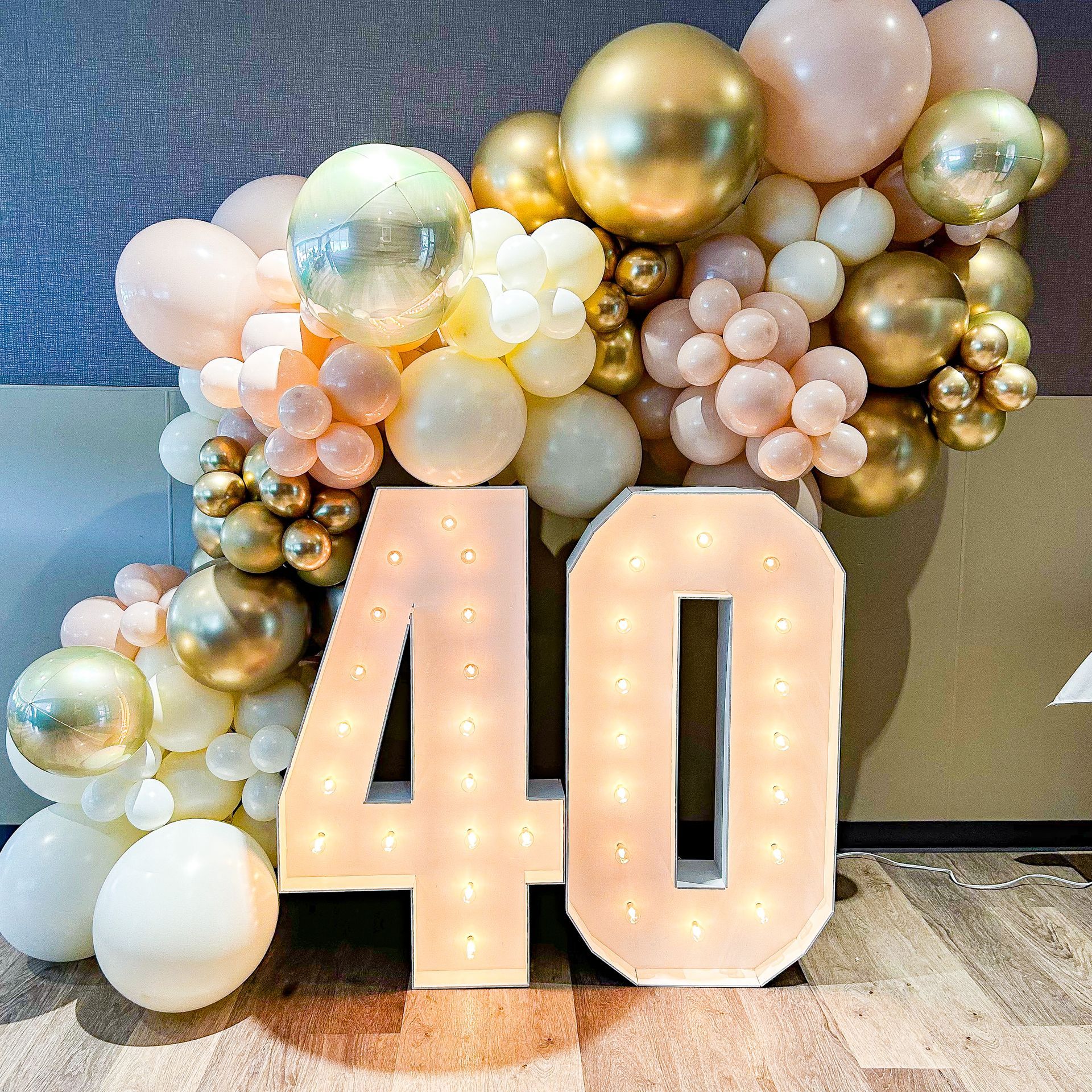 The number 40 is surrounded by balloons and lights.