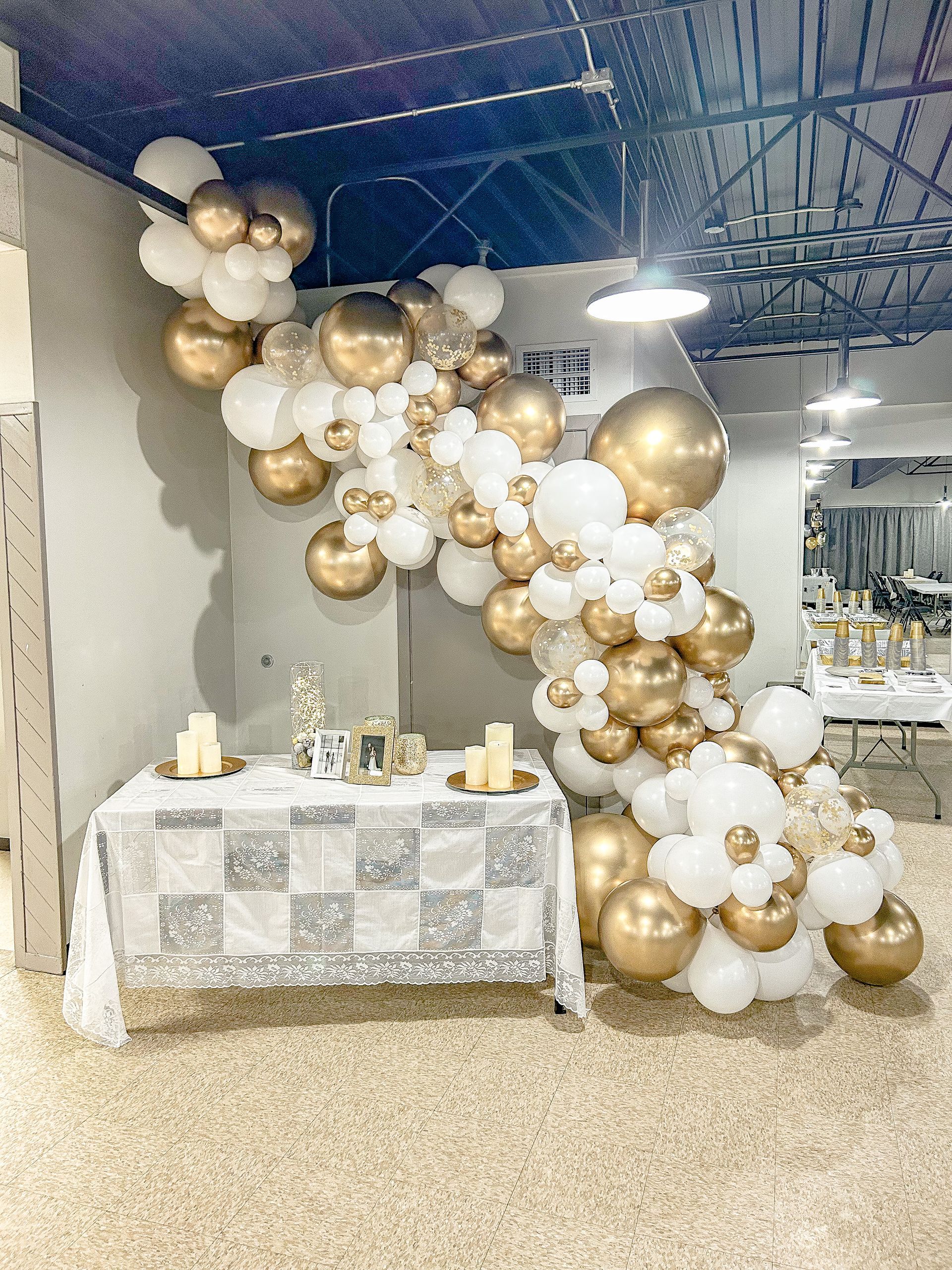 A room filled with gold and white balloons and a table.