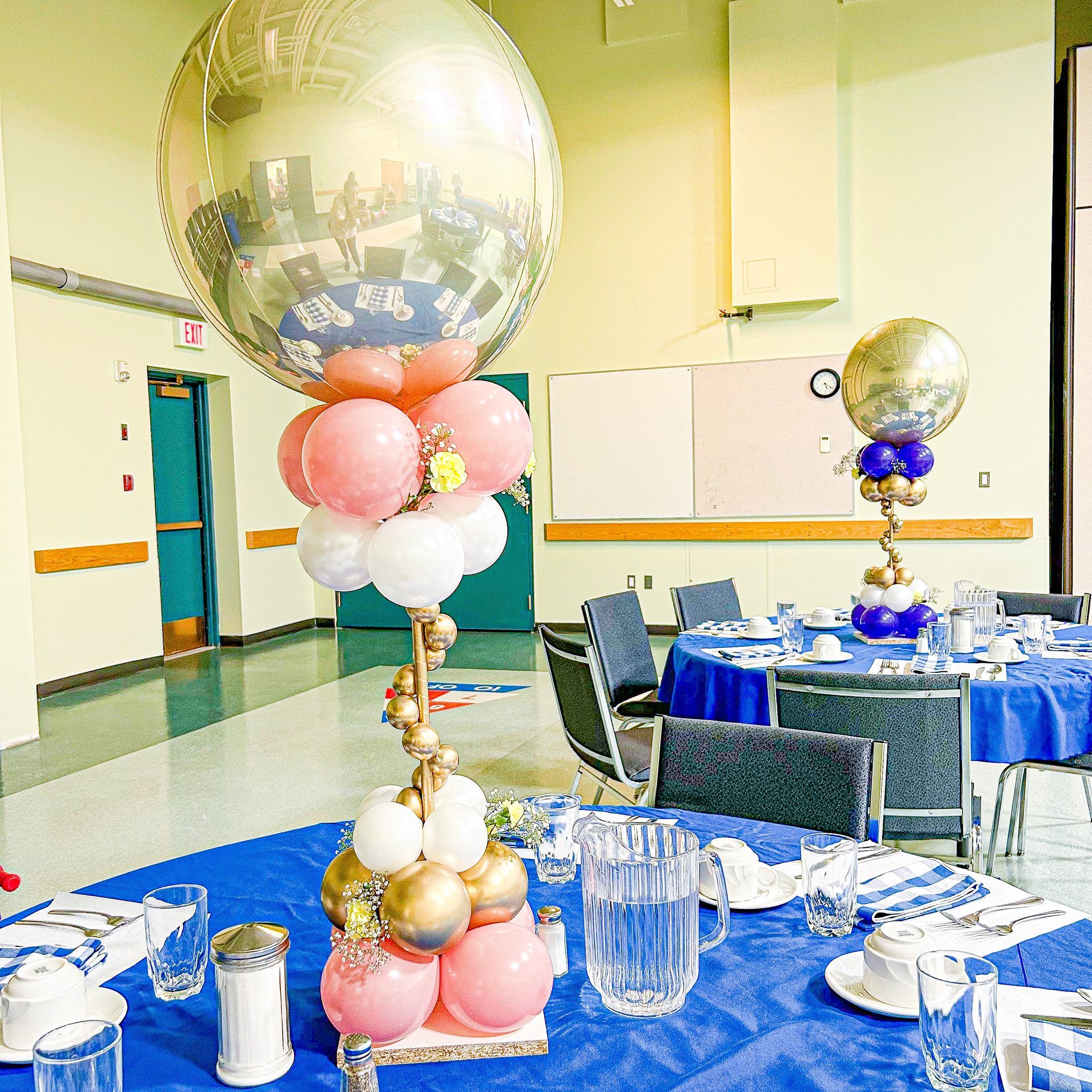 A large balloon is surrounded by pink and white balloons