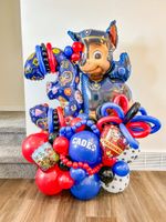 A bunch of colorful balloons are sitting on the floor in a room.