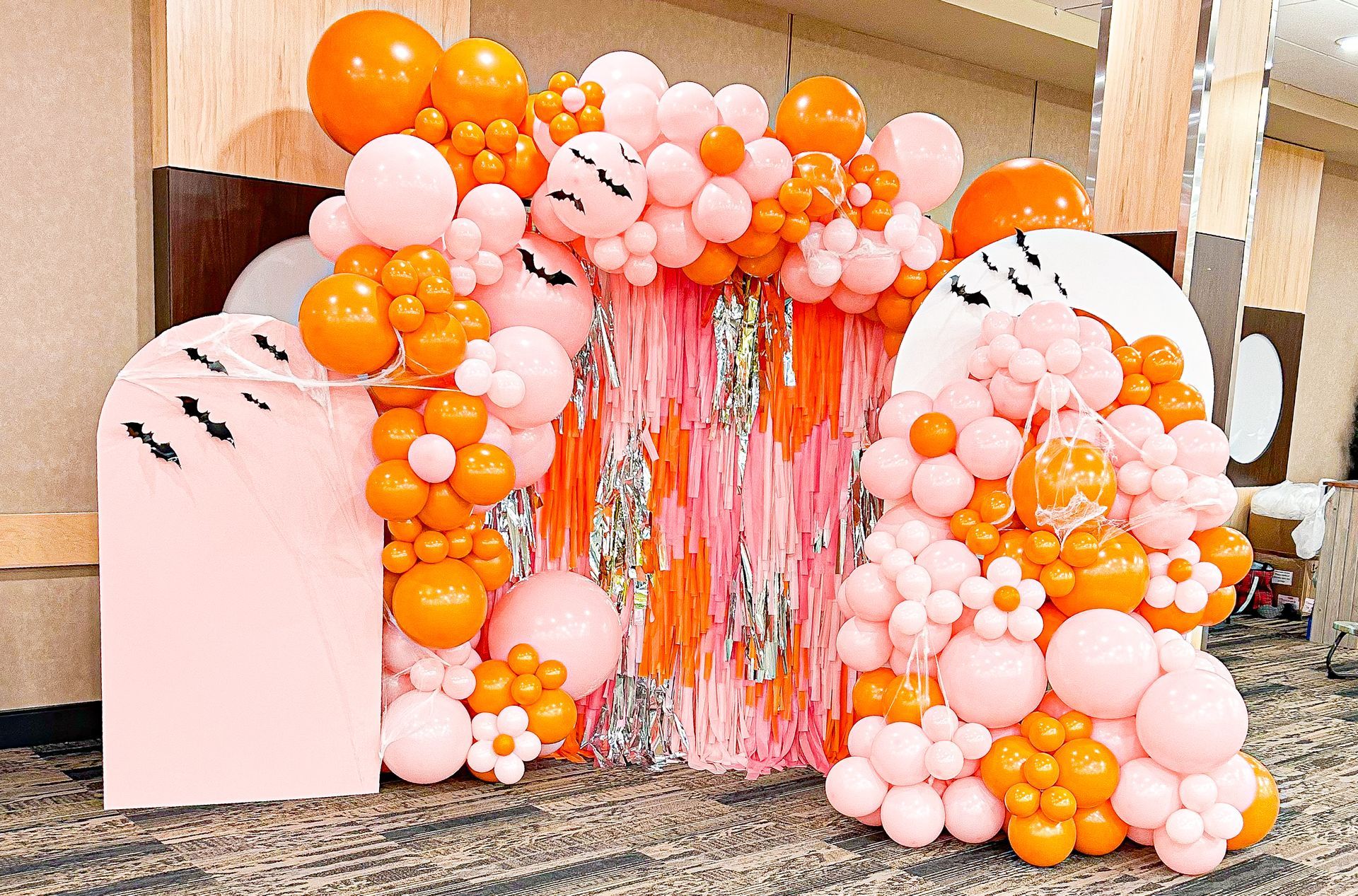 A bunch of pink and orange balloons are sitting on a table.