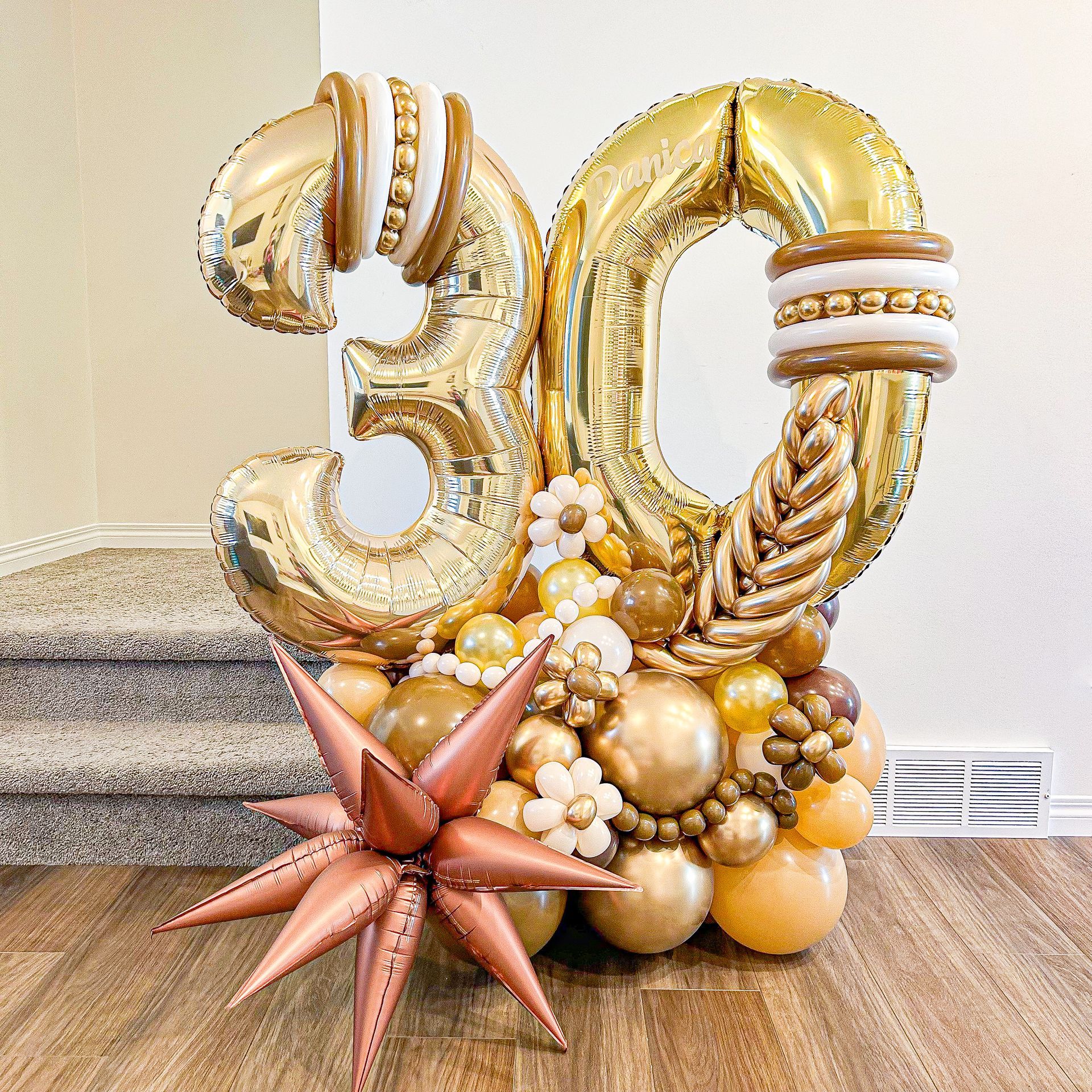 A bunch of balloons shaped like the number 30 are sitting on a wooden floor.