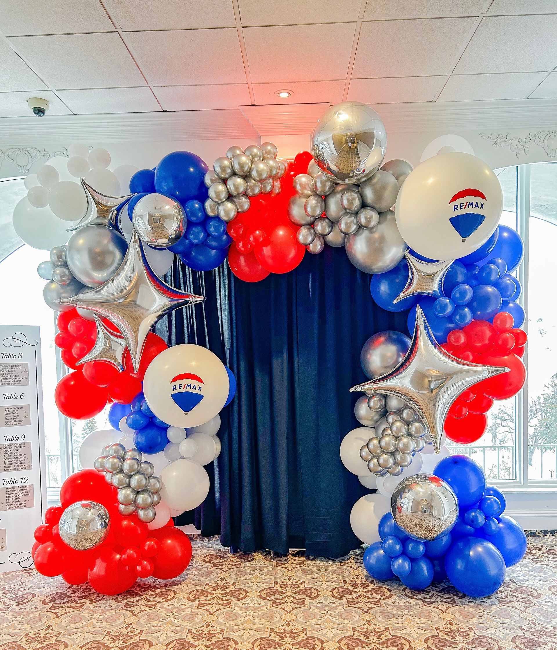 A room filled with red , white and blue balloons