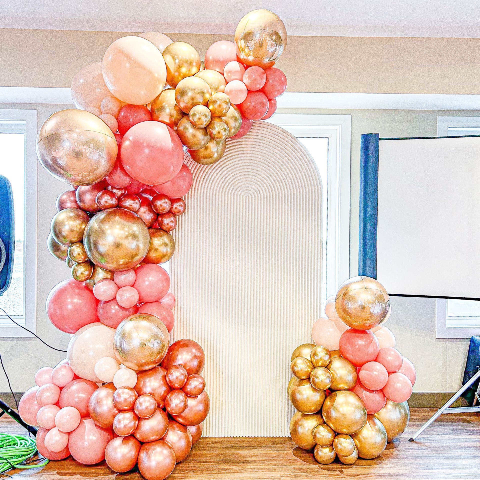 A room filled with lots of pink and gold balloons.