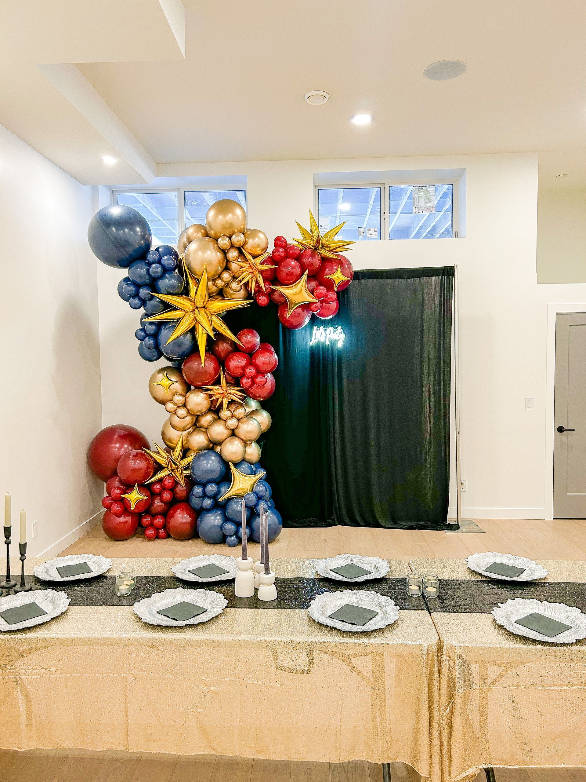 A room with a table and plates and balloons on the wall.