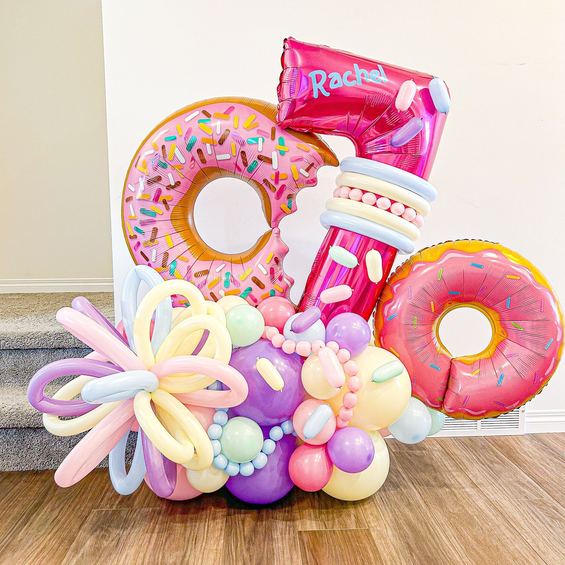 A bunch of balloons shaped like donuts and the number 7