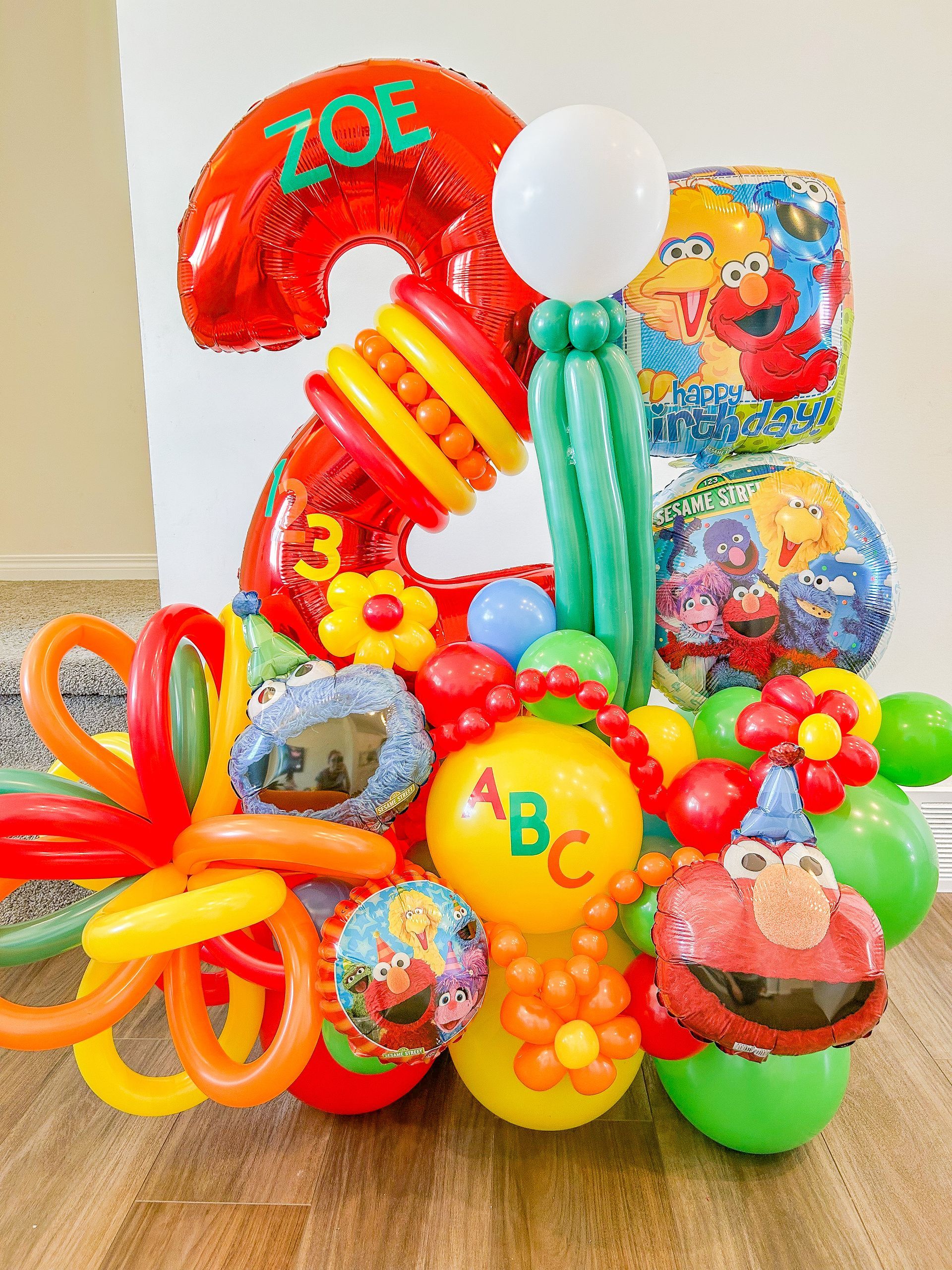 A bunch of balloons are sitting on a wooden floor.