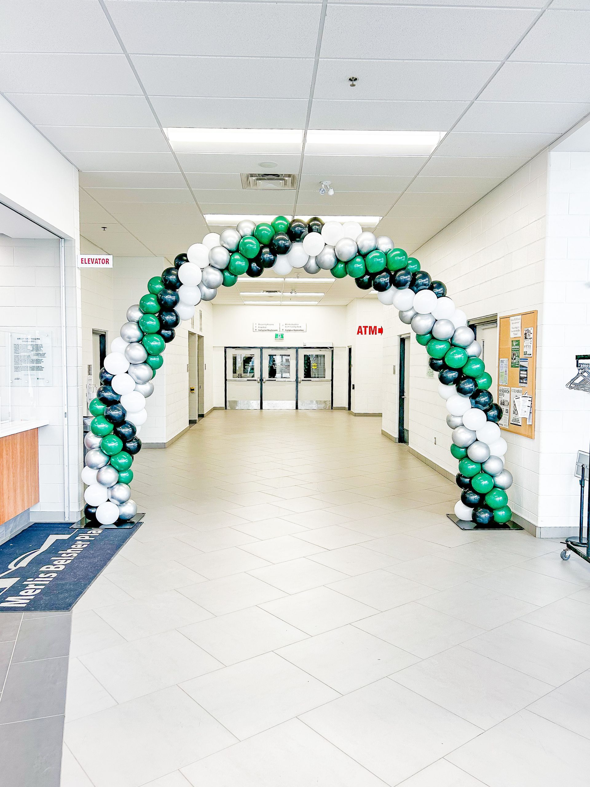 A hallway with a balloon arch in the middle of it.