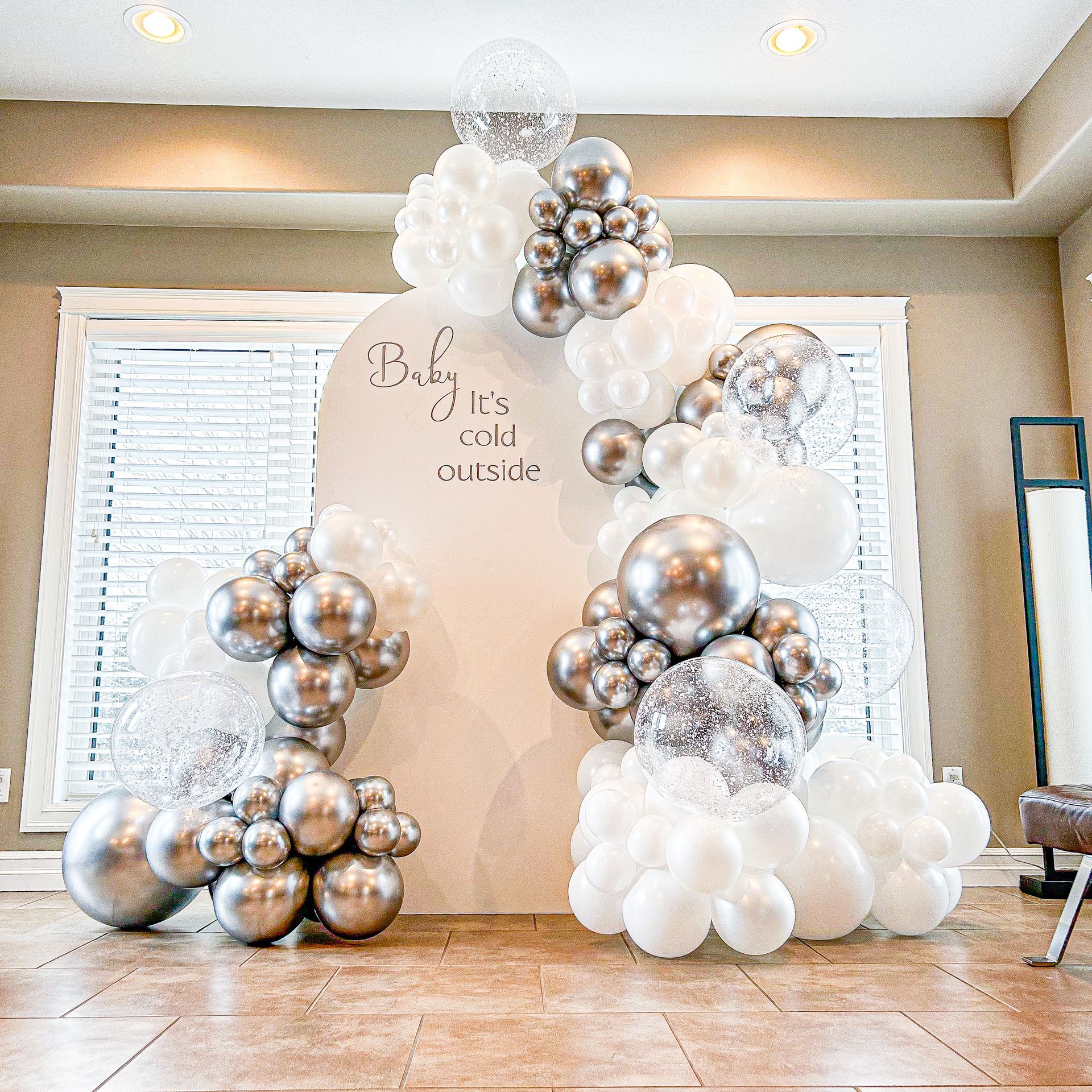 A room filled with lots of white and silver balloons.
