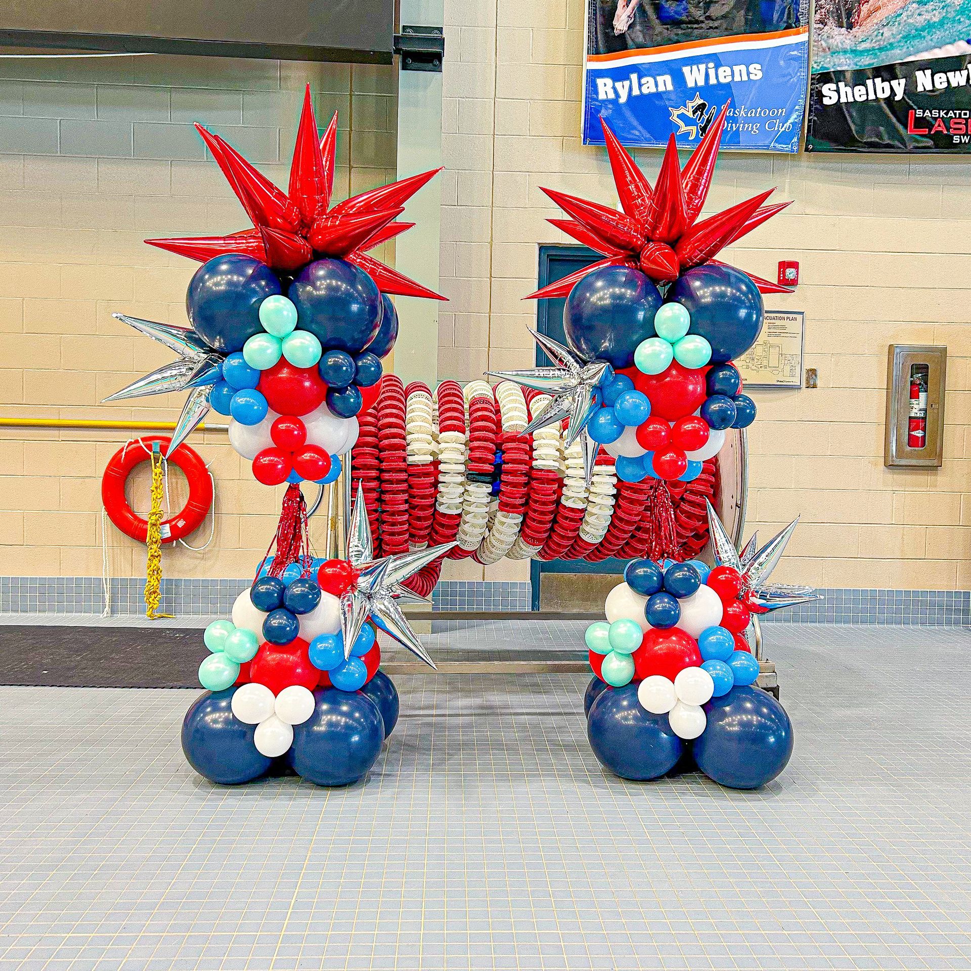 A bunch of red white and blue balloons in the shape of the letter h