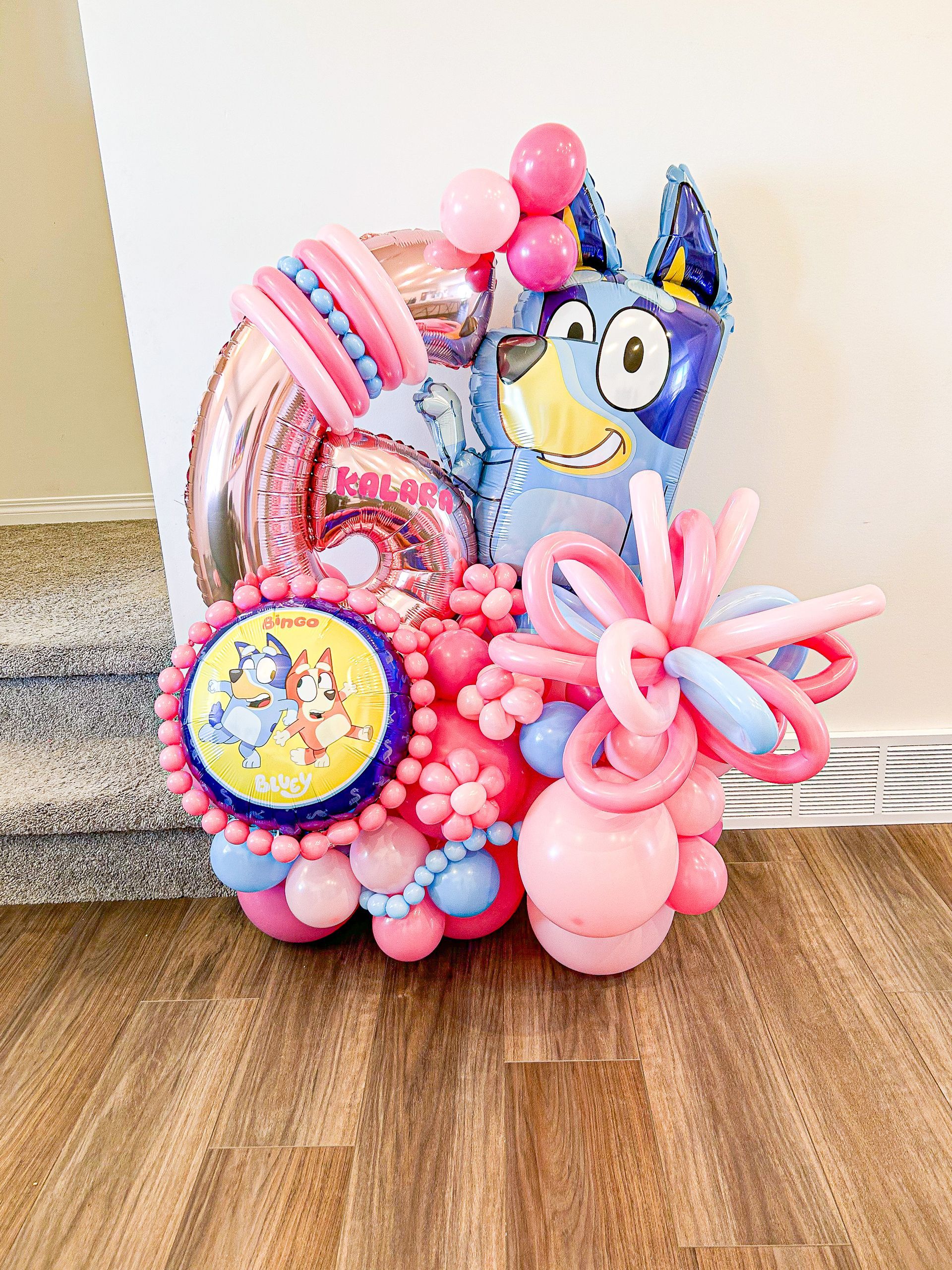 A bunch of balloons are sitting on a wooden floor.