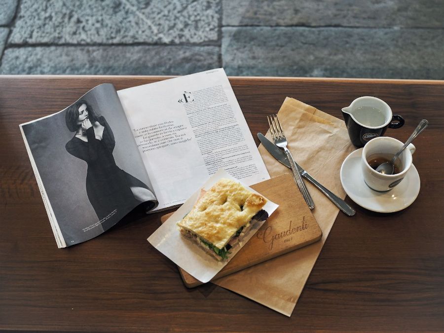 table with coffee, savoury focaccia and magazine