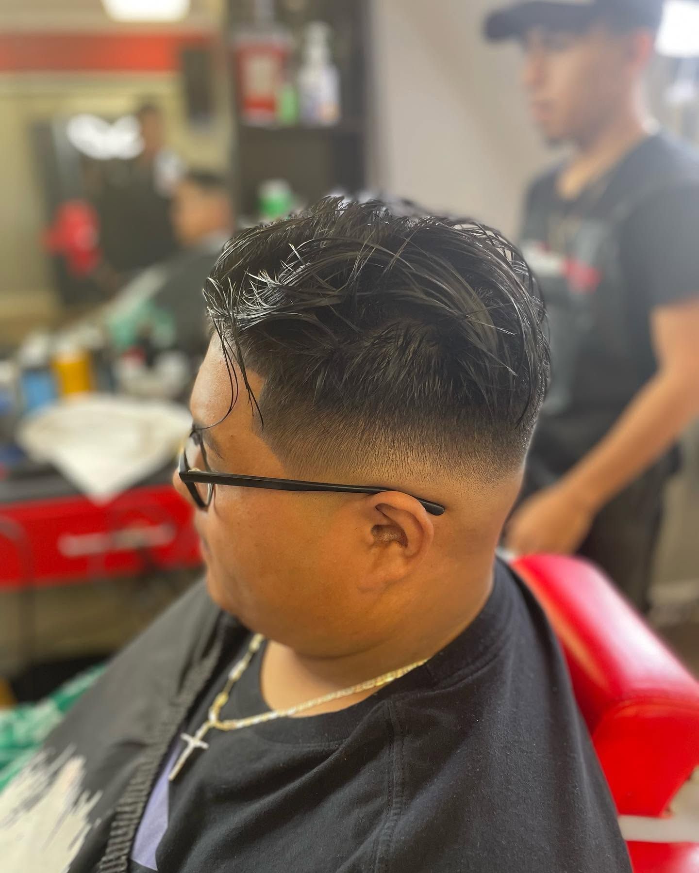 A man is getting his hair cut at a barber shop