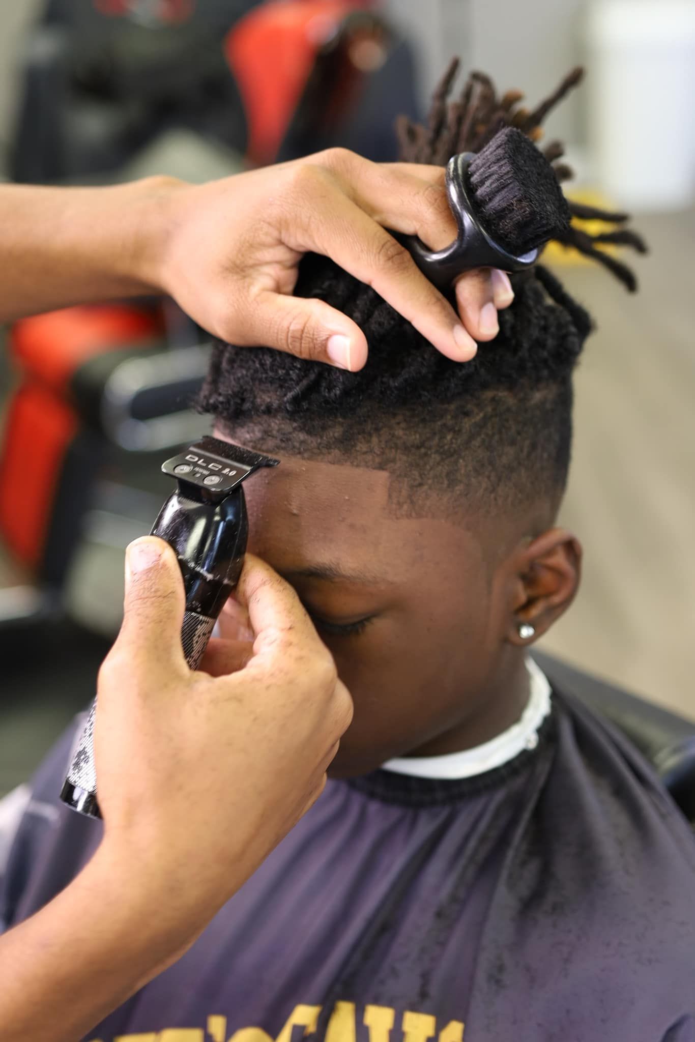 A young boy is getting his hair cut by a barber.