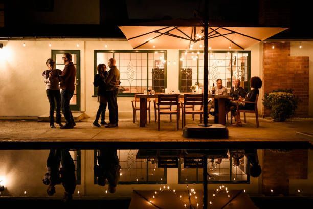 A group of people are dancing on a patio at night.
