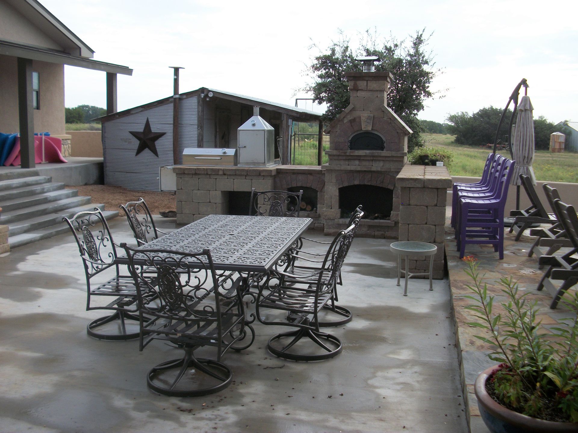 A patio with a table and chairs and a fireplace
