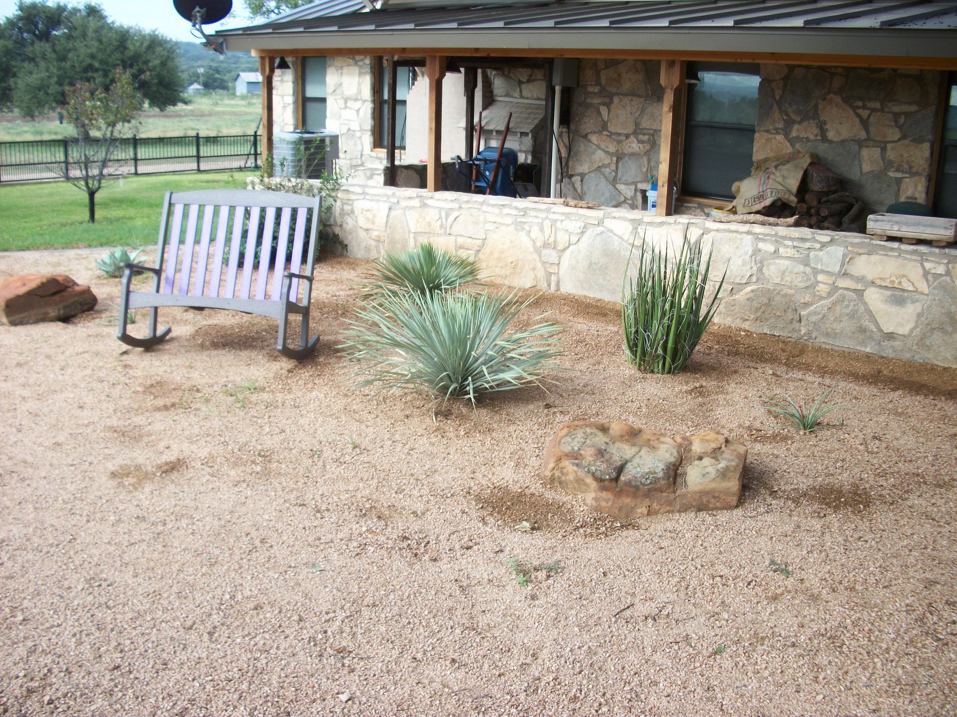 A rocking chair sits in front of a stone house