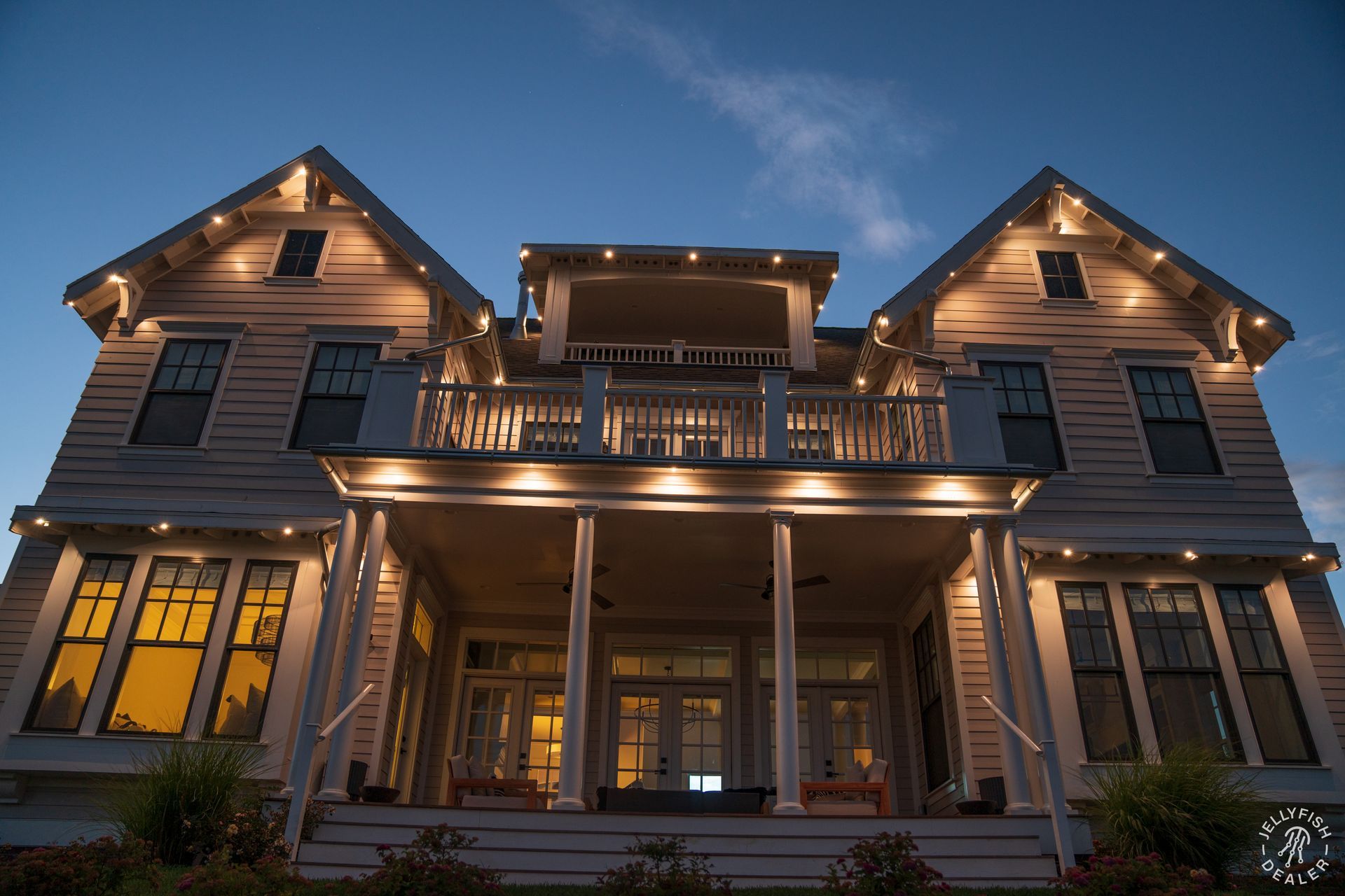 The front of a large house is lit up at night