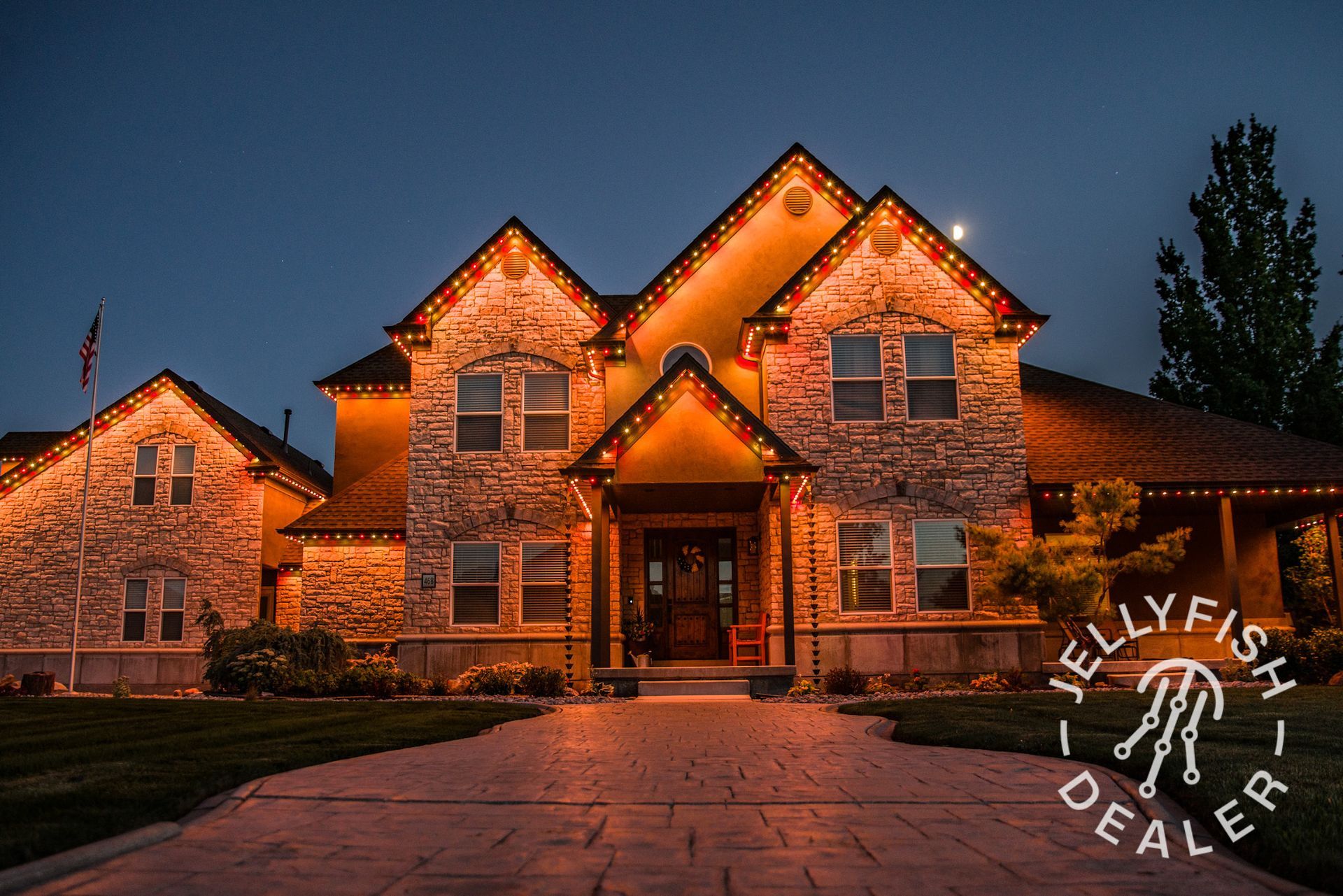 A large house is lit up with christmas lights and the word dealer is on the bottom right