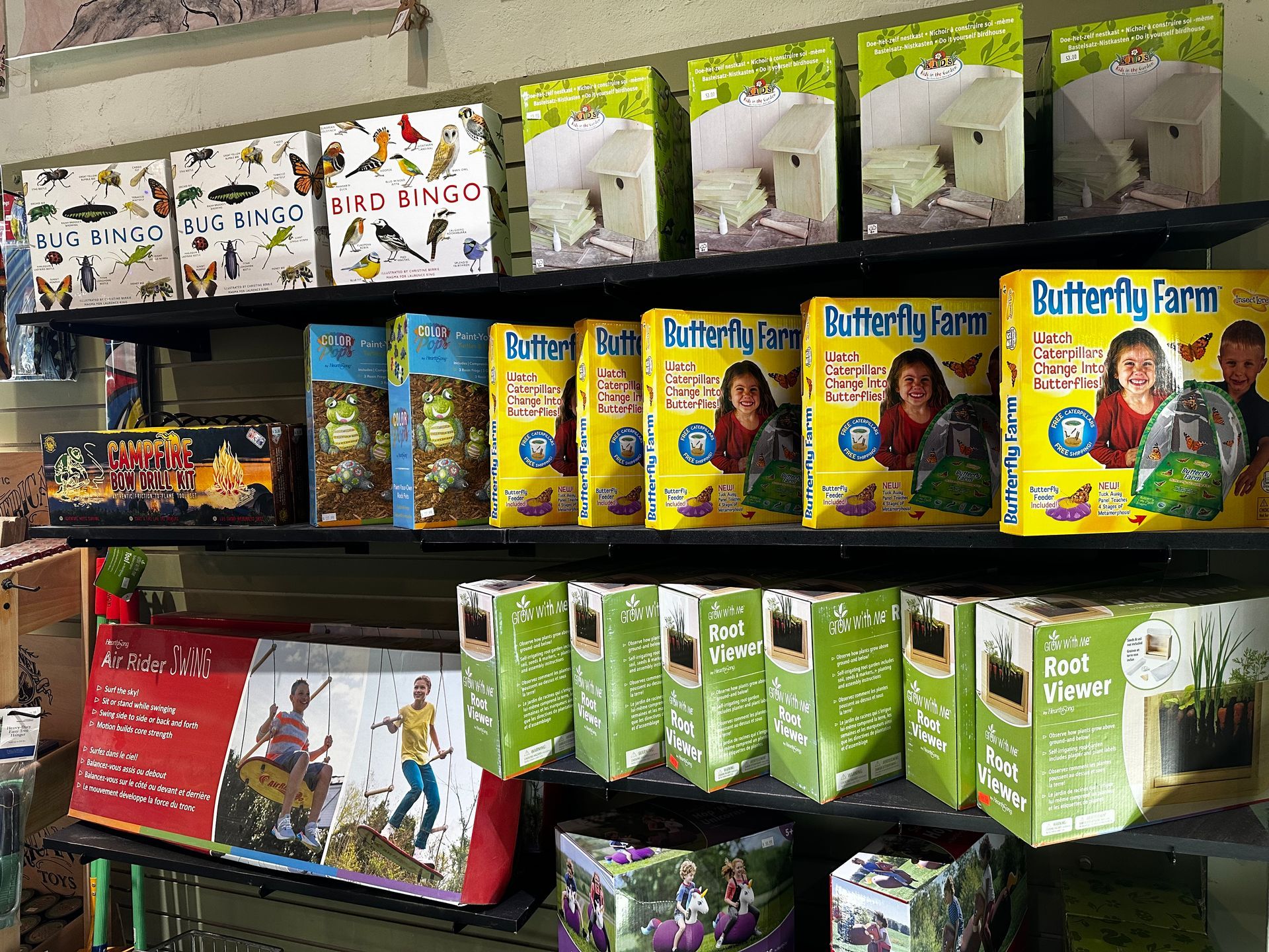 A shelf filled with boxes of butterfly farm products