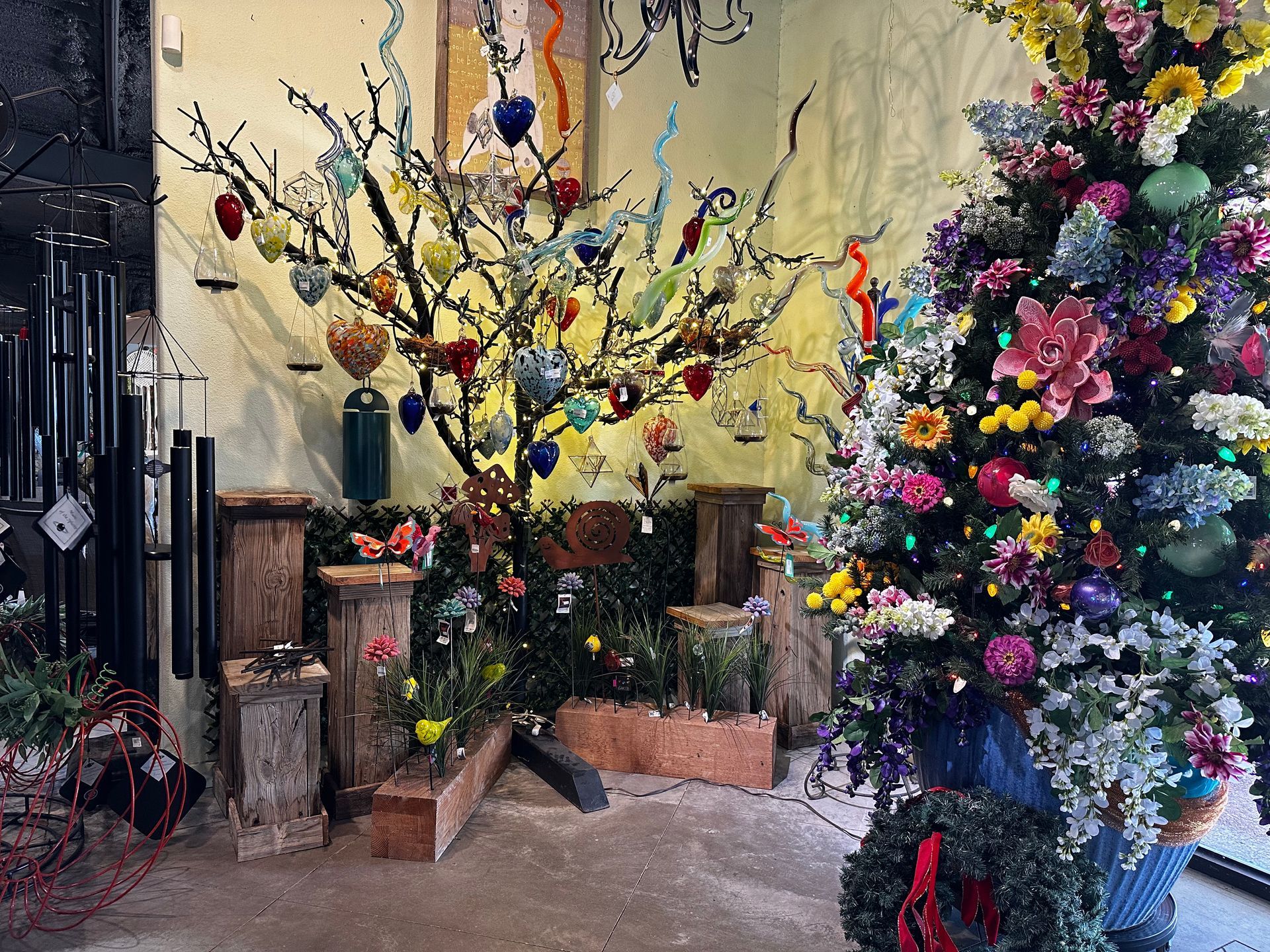 A christmas tree is decorated with flowers and decorations in a room.