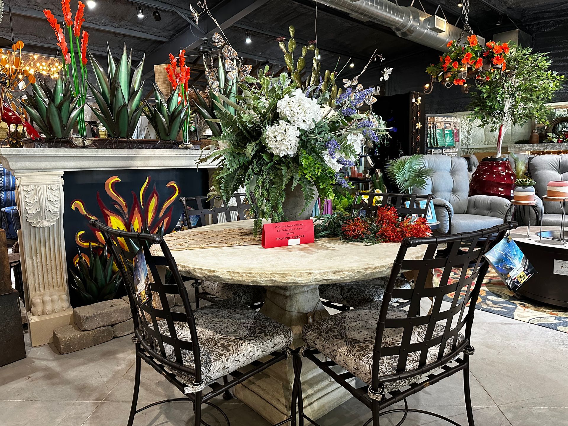 A table and chairs in a room with a vase of flowers on it.