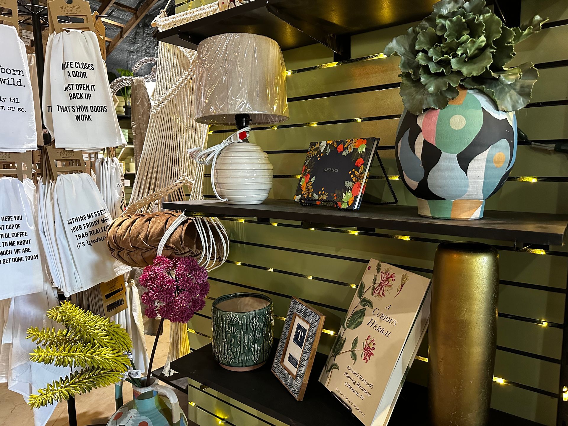 A shelf filled with vases , lamps , books , and other items.