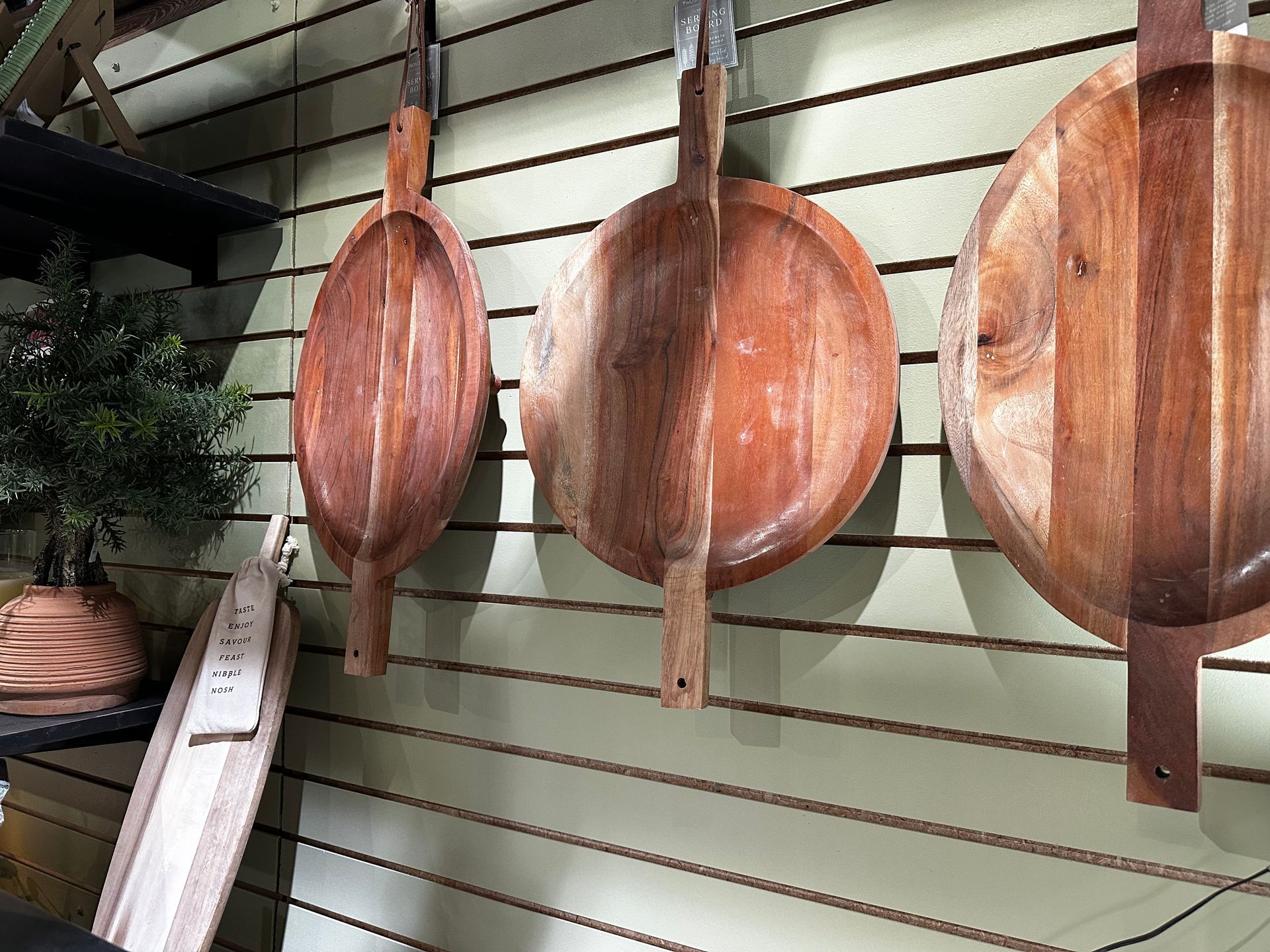 Three wooden bowls are hanging on a wall.