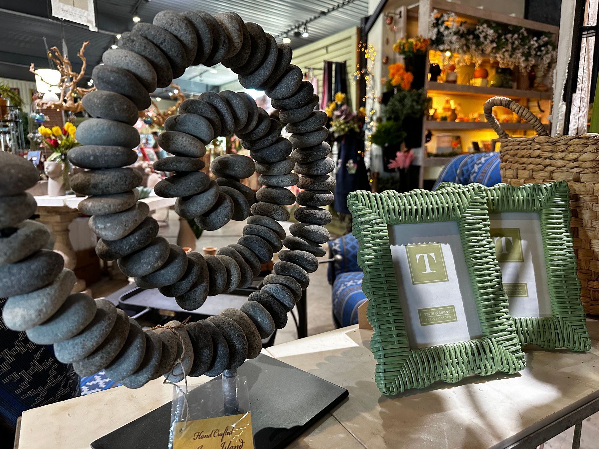 A table with a picture frame and a sculpture made of rocks.