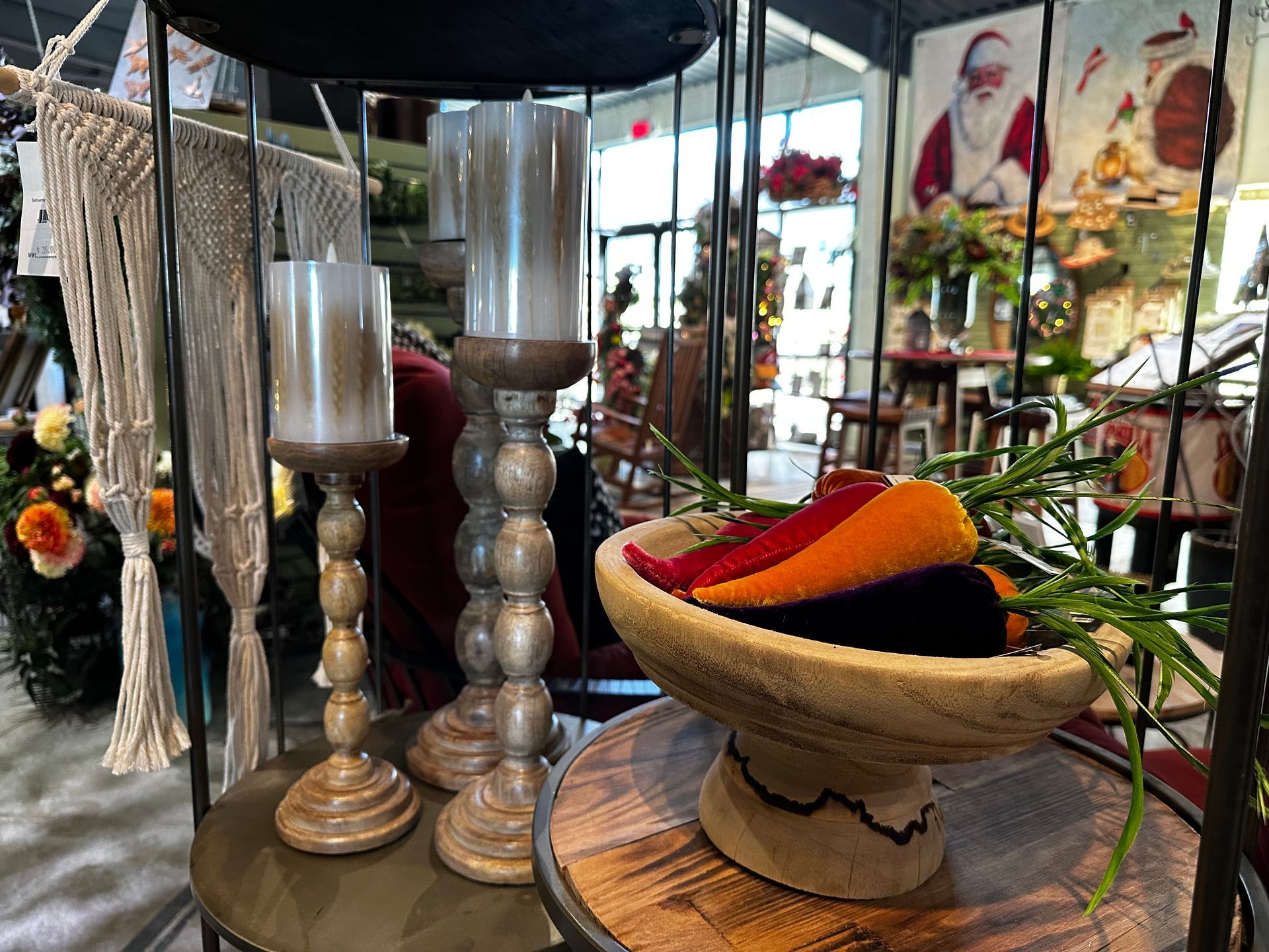 A display of candles and a bowl of flowers on a table in a store.