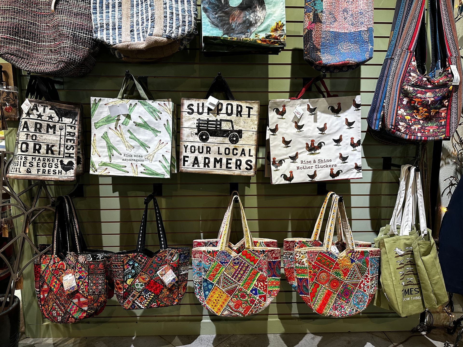 A wall filled with lots of bags and a sign that says `` support your local farmers ''.
