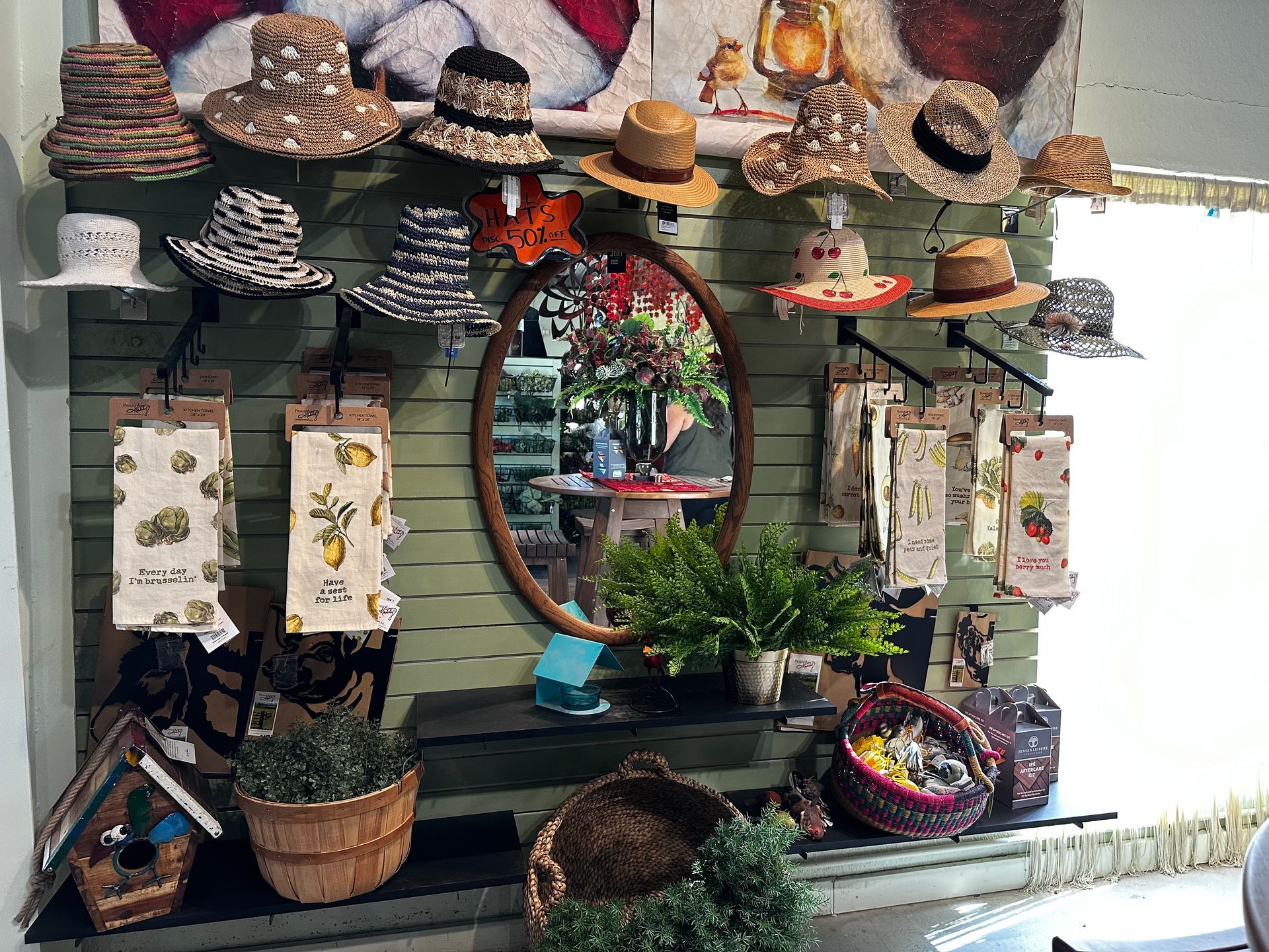 A wall with a lot of hats on it and a mirror