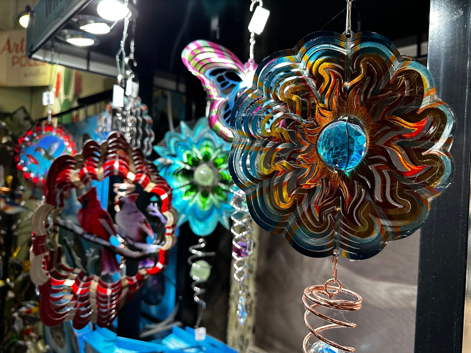 A bunch of colorful wind spinners are hanging from the ceiling