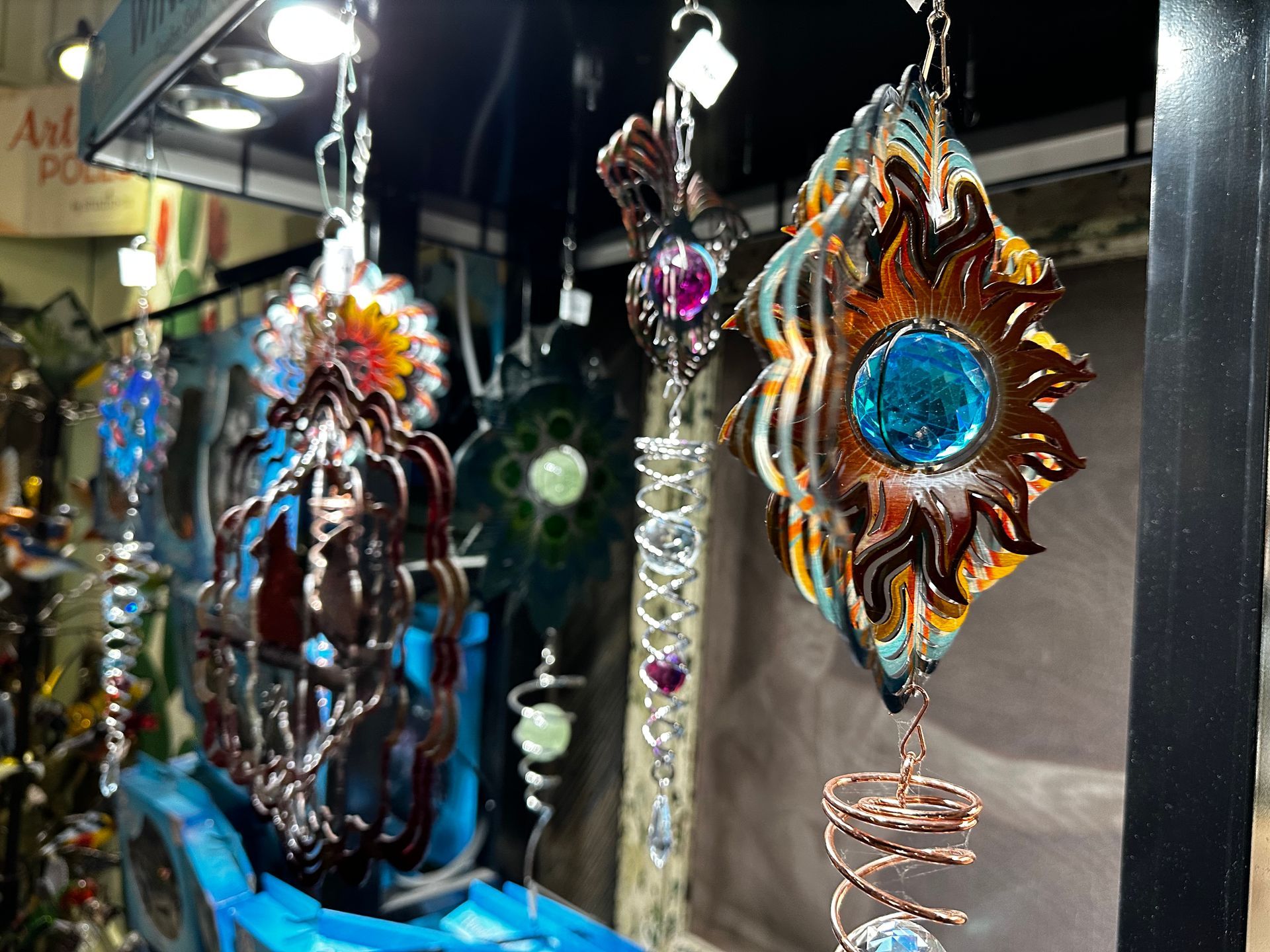 A display of wind spinners hanging from a ceiling in a store