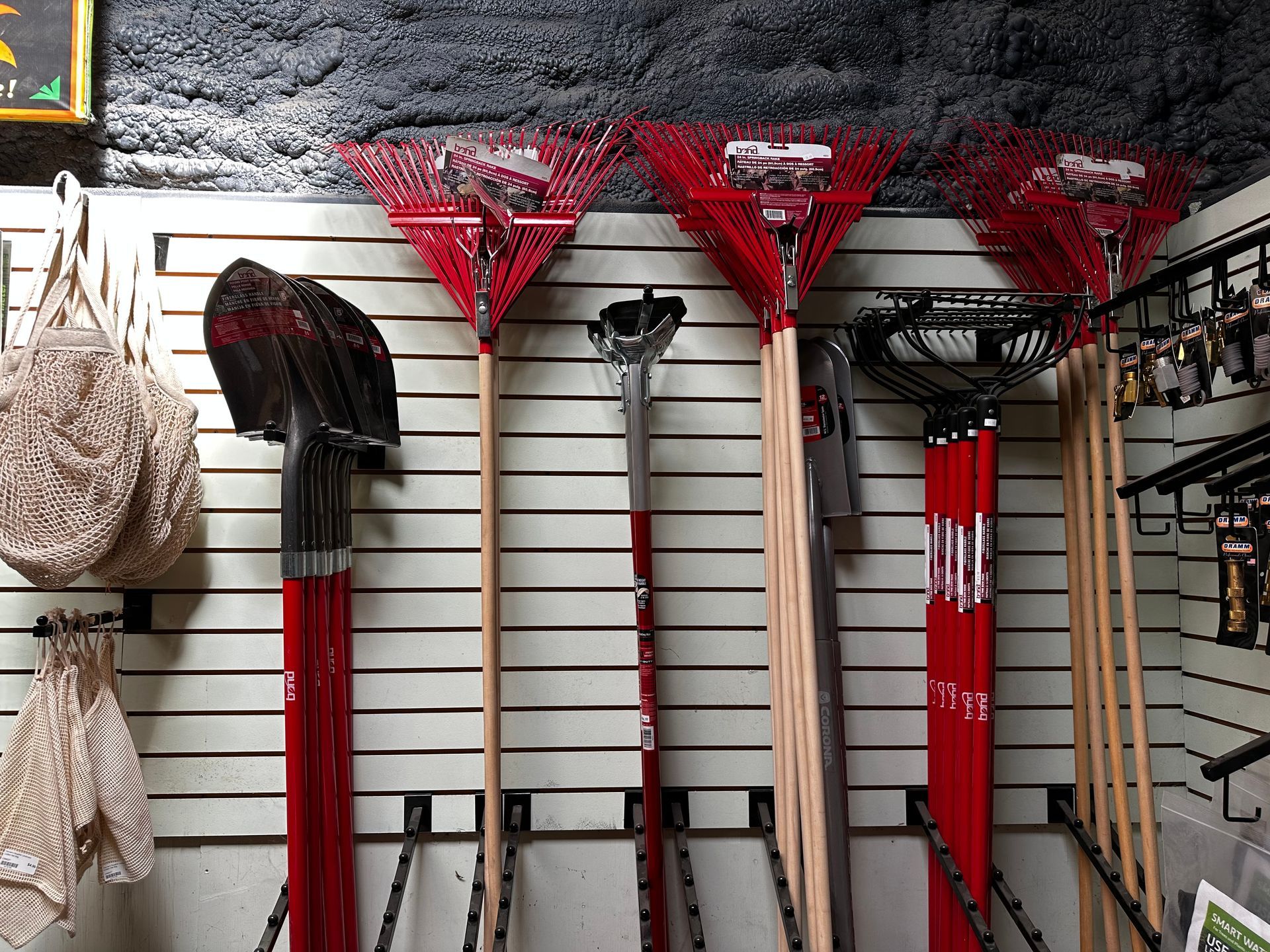 A bunch of gardening tools are hanging on a wall