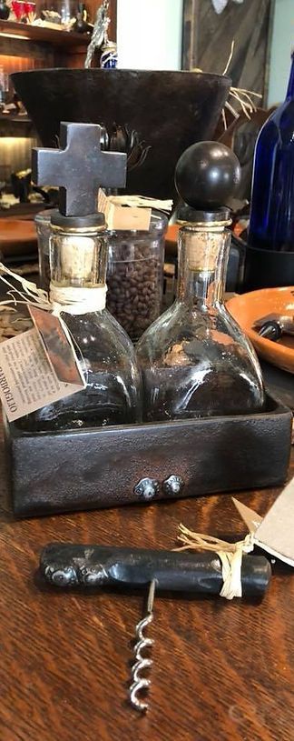 A wooden tray with two bottles and a corkscrew on a wooden table.