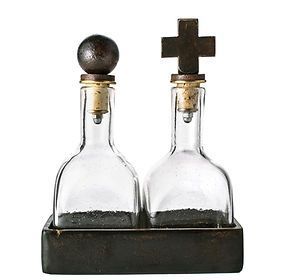 Two glass bottles with wooden corks and a cross on top of them.