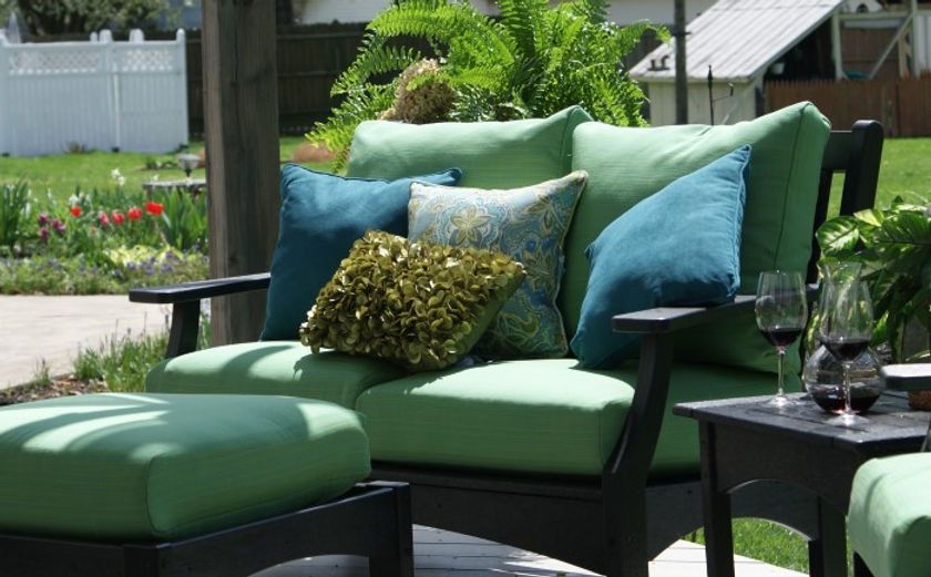 A patio set with green cushions and blue pillows