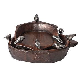 A wooden bowl with birds on top of it on a white background.