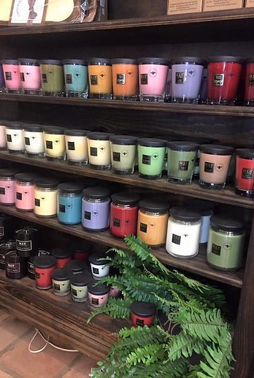 A shelf filled with lots of different colored candles.